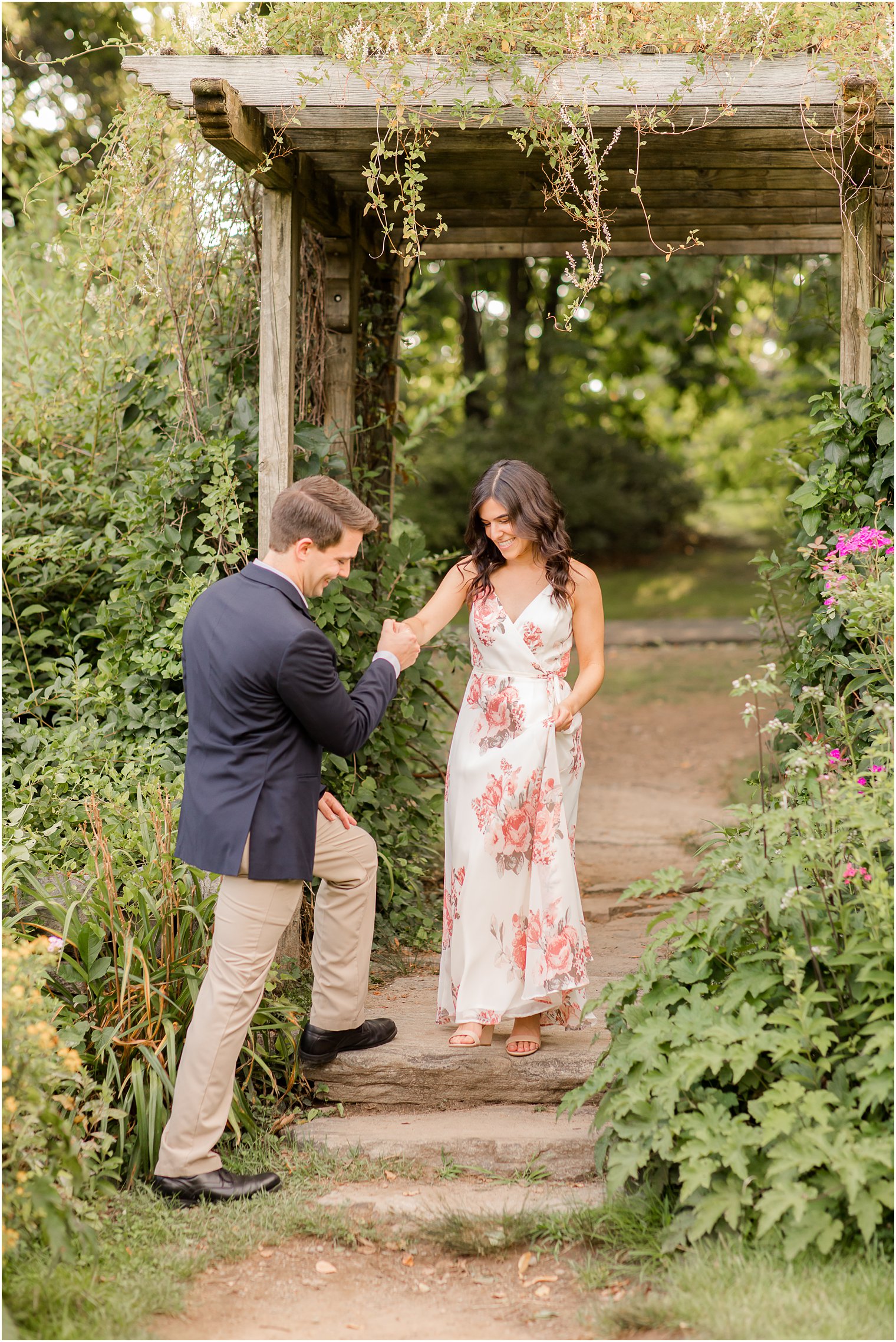 groom helps bride down steps during Skylands Manor engagement session
