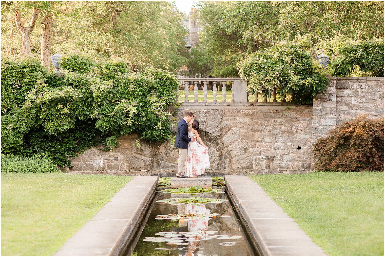bride and groom kiss at end of pond during Skylands Manor engagement session