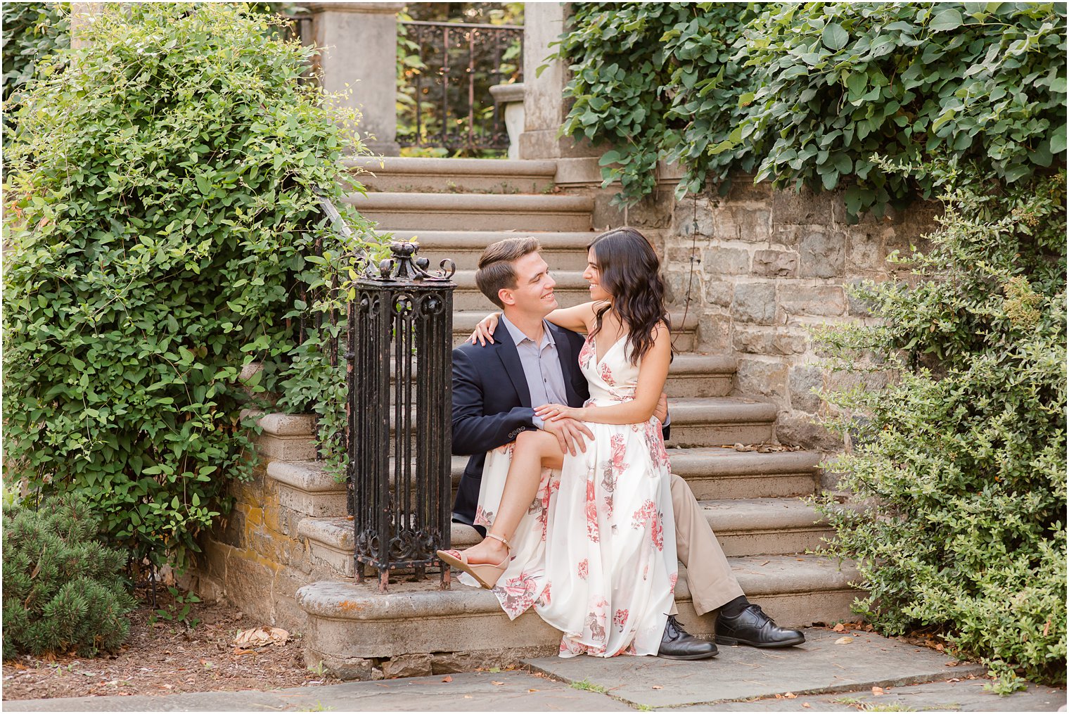 bride and groom sit on steps during Skylands Manor engagement session