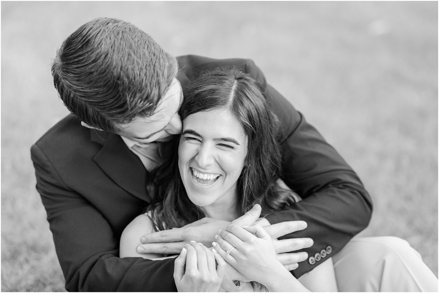 groom hugs bride while laughing during NJ engagement photos 