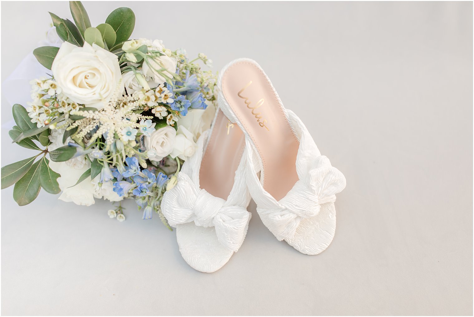 bride's shoes with white bowes for beach wedding