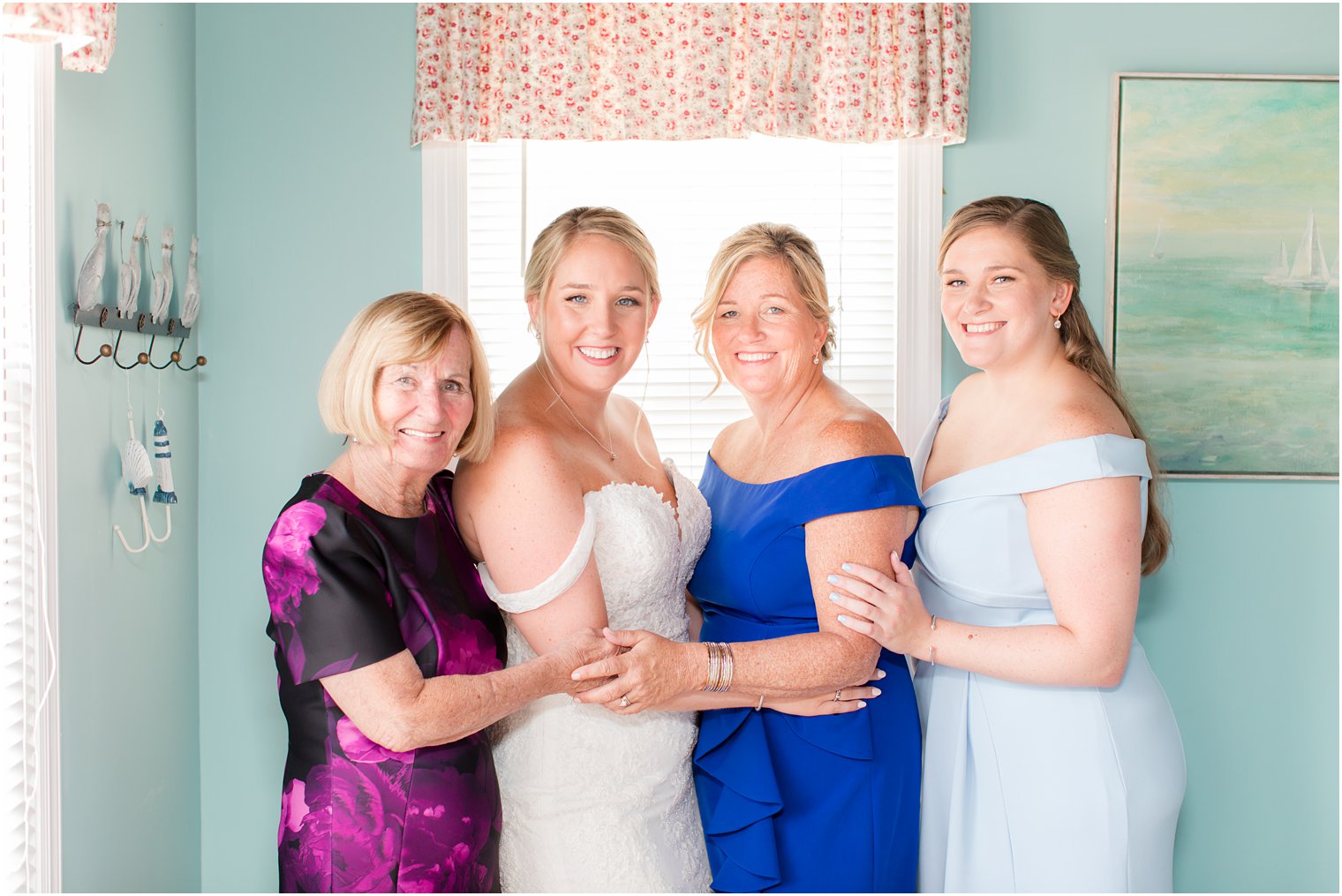 bride poses with mom, sister and grandmother on wedding day