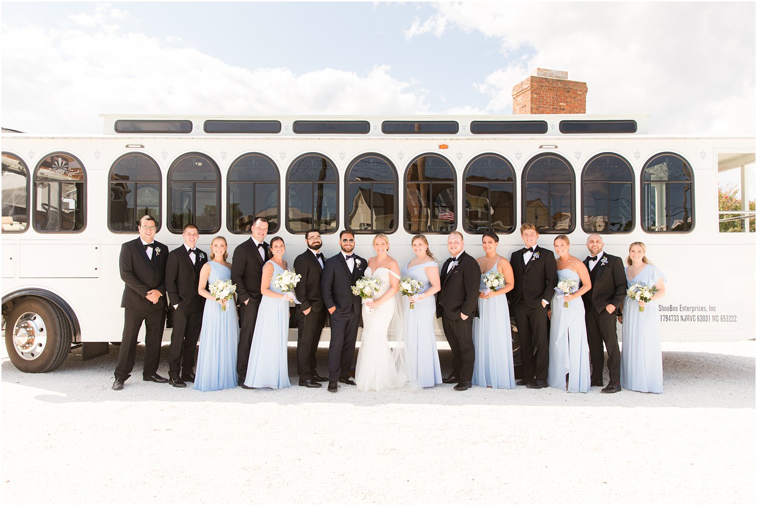 bride and groom pose with wedding party in blue and black