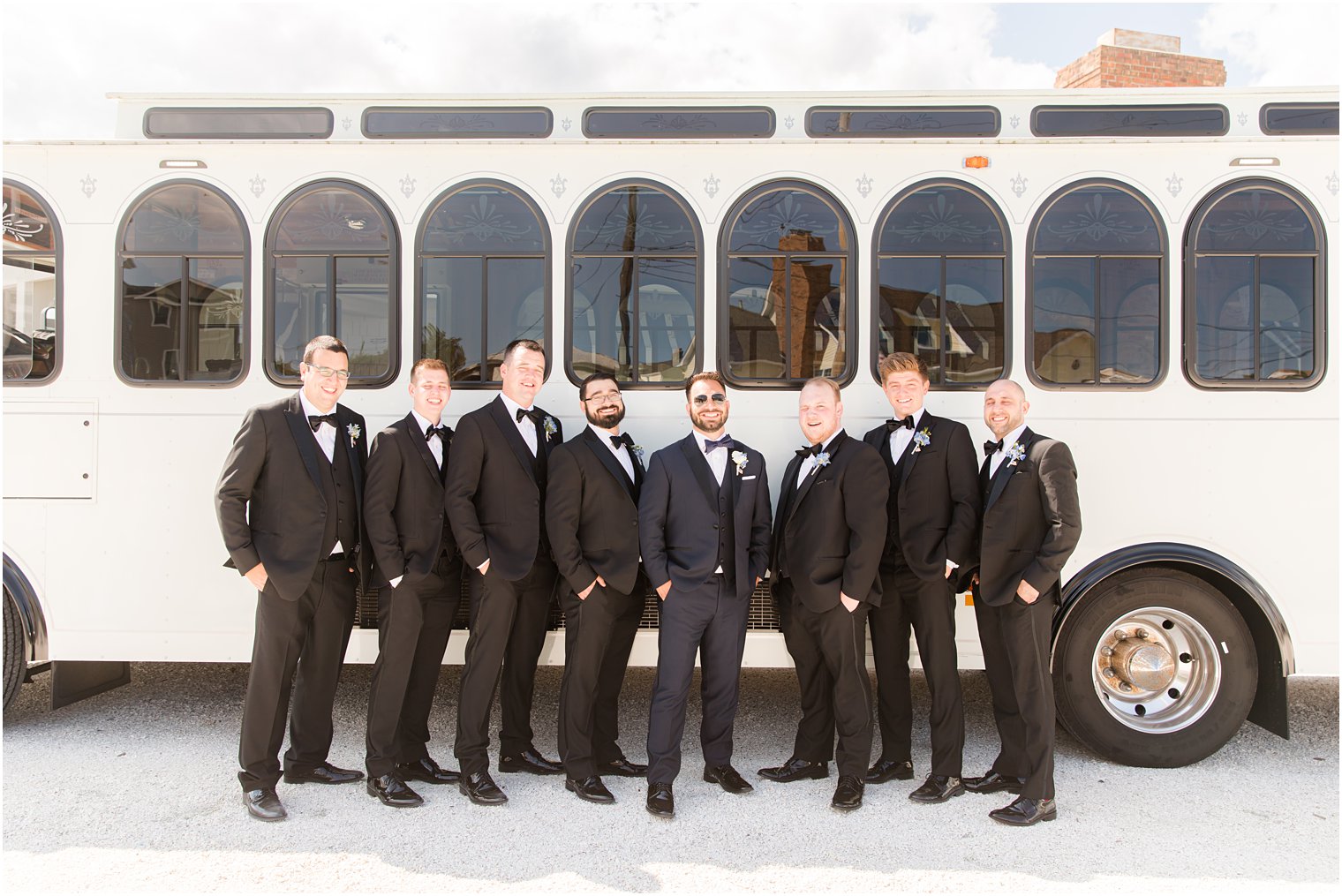 groom and groomsmen pose by white trolley on LBI
