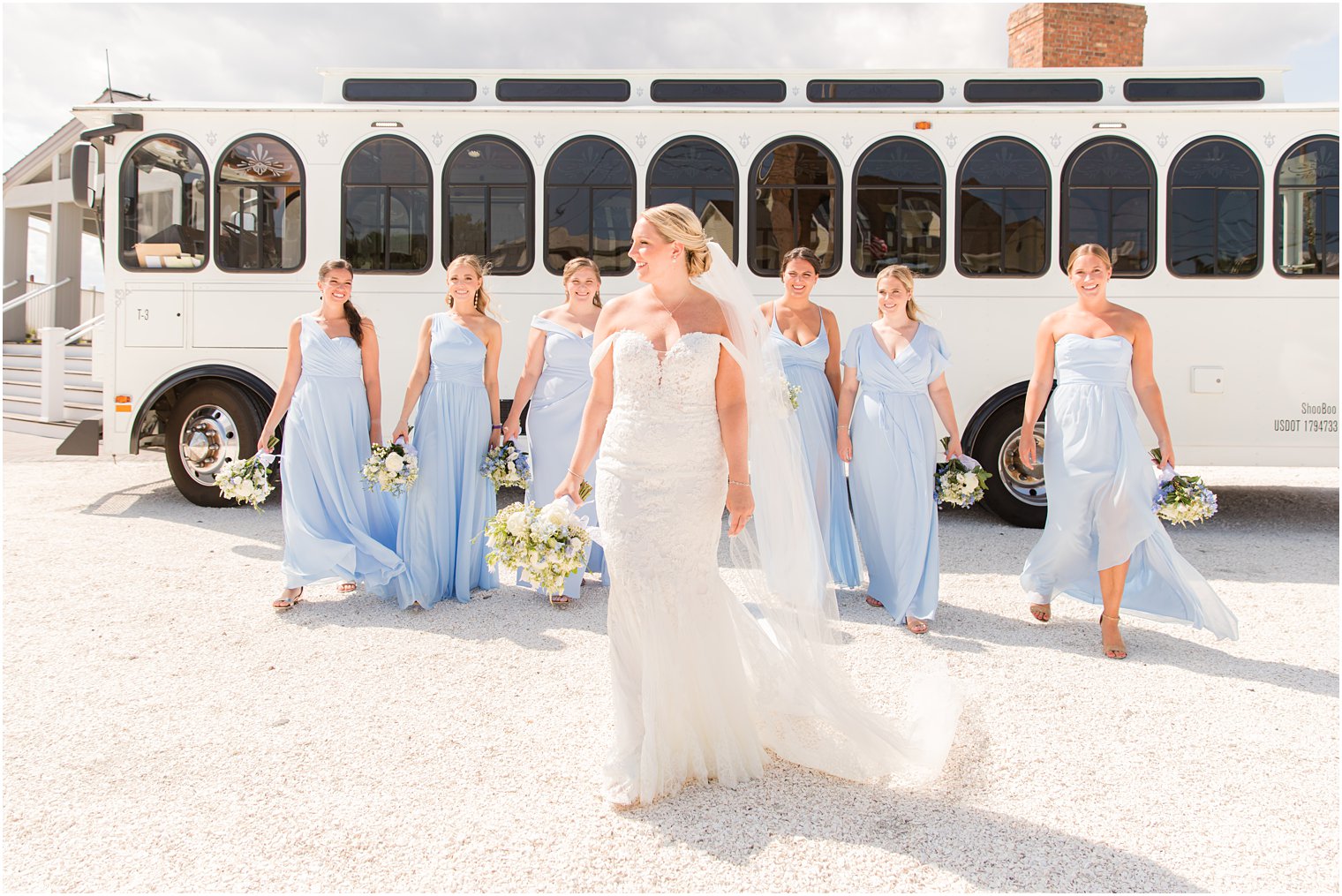 bride walks with bridesmaids by trolley at Brant Beach Yacht Club