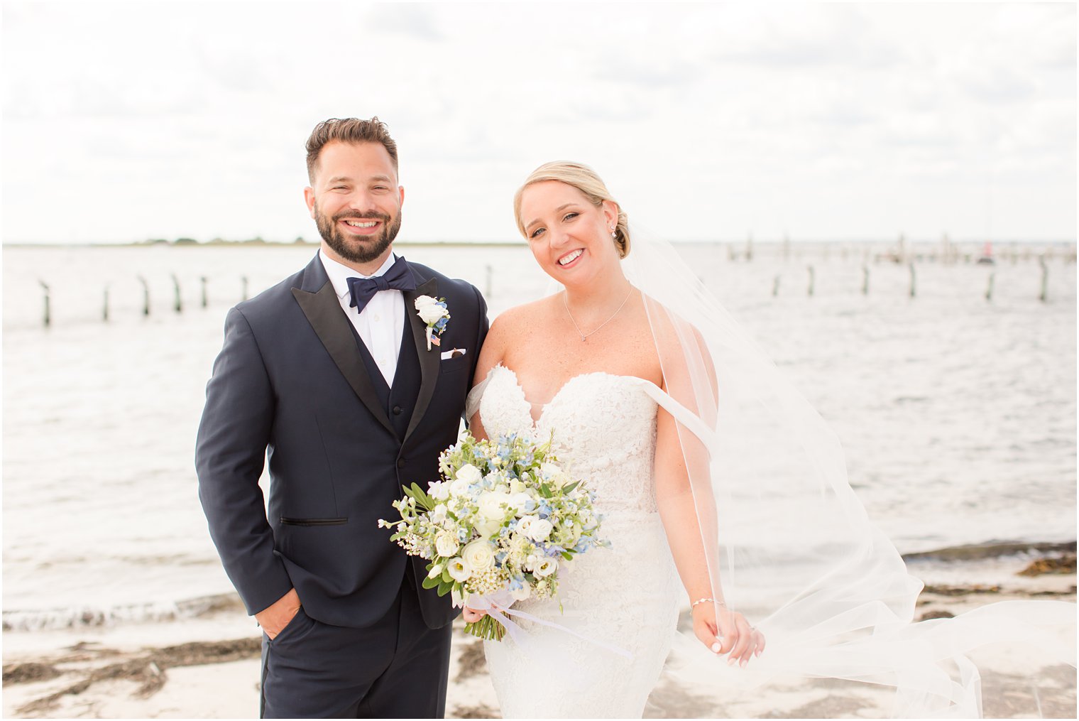 bride and groom pose on beach during NJ wedding portraits 