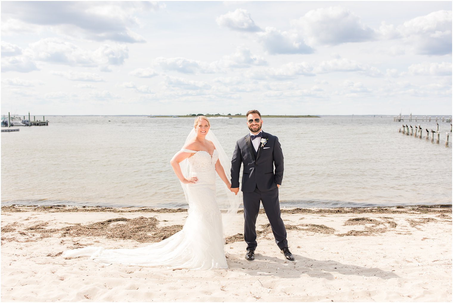 newlyweds hold hands standing on the beach in New Jersey 