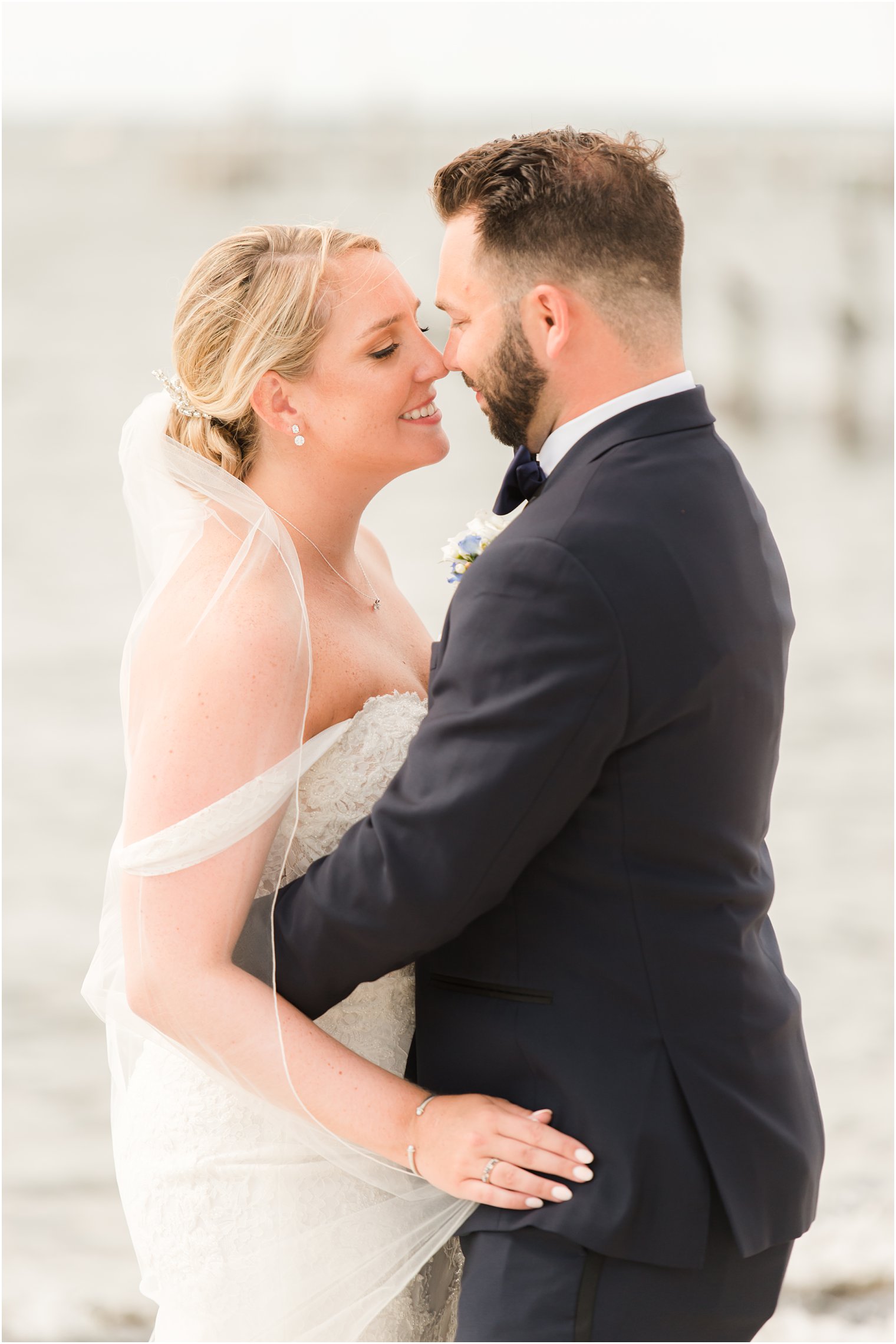 bride and groom pose nose to nose on Brant Beach