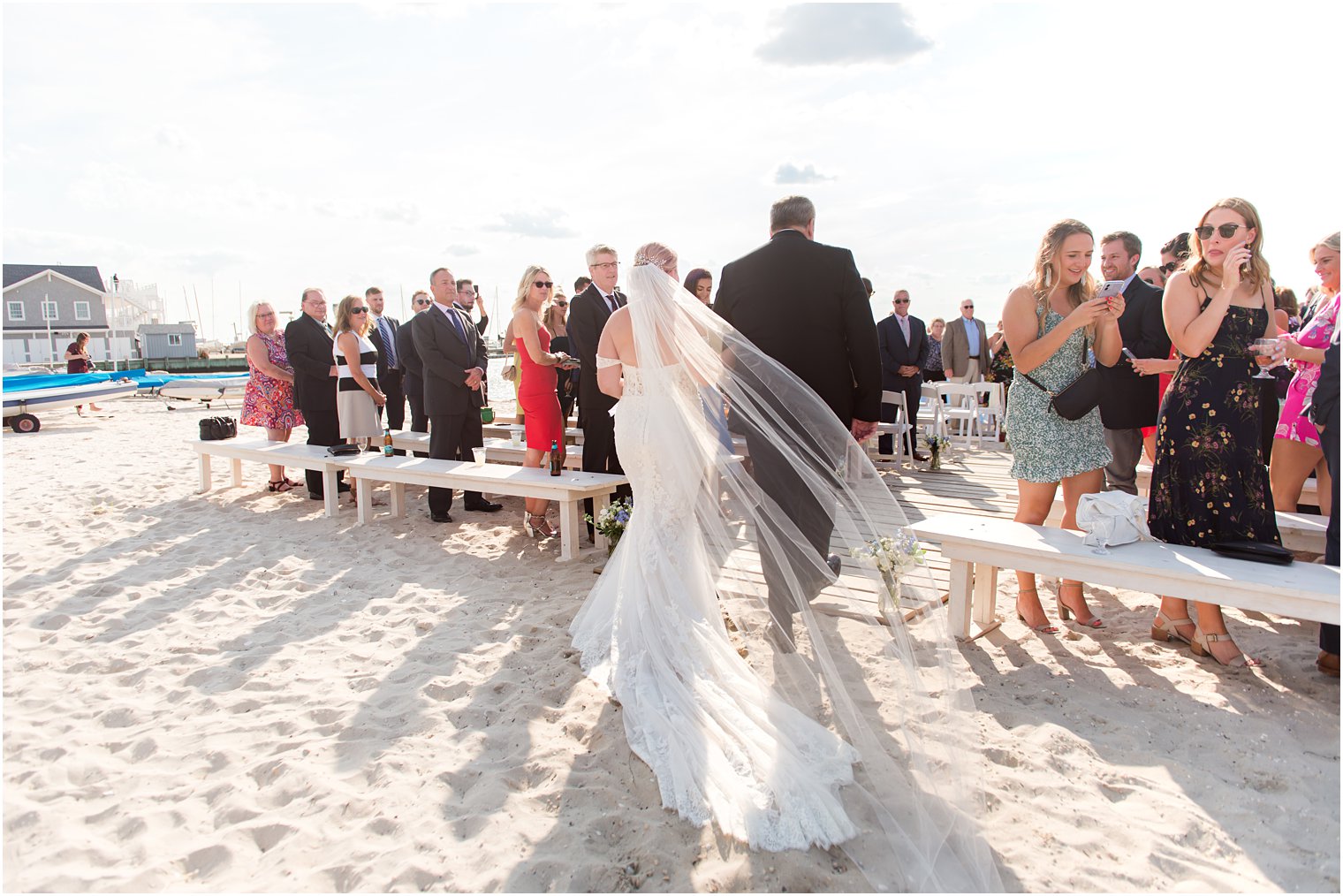 bride walks down aisle for waterfront beach ceremony