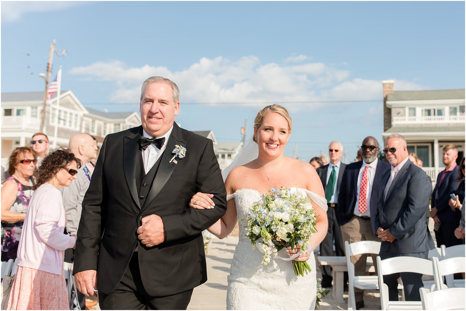 bride and dad enter waterfront beach ceremony in New Jersey 