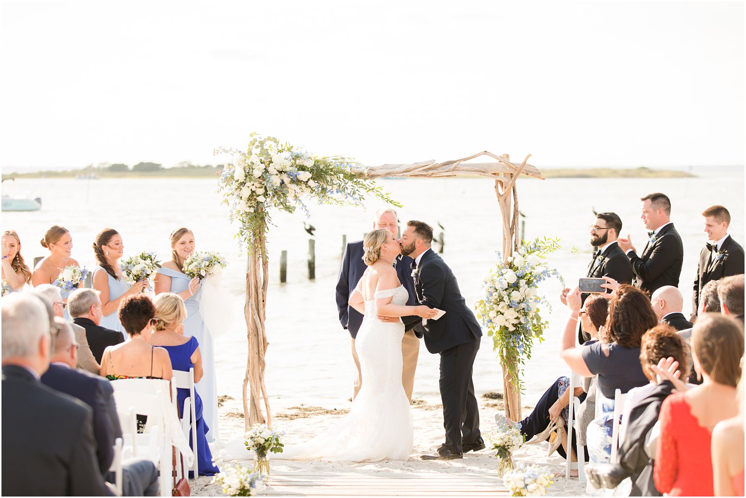 couple kisses during waterfront beach ceremony in New Jersey 