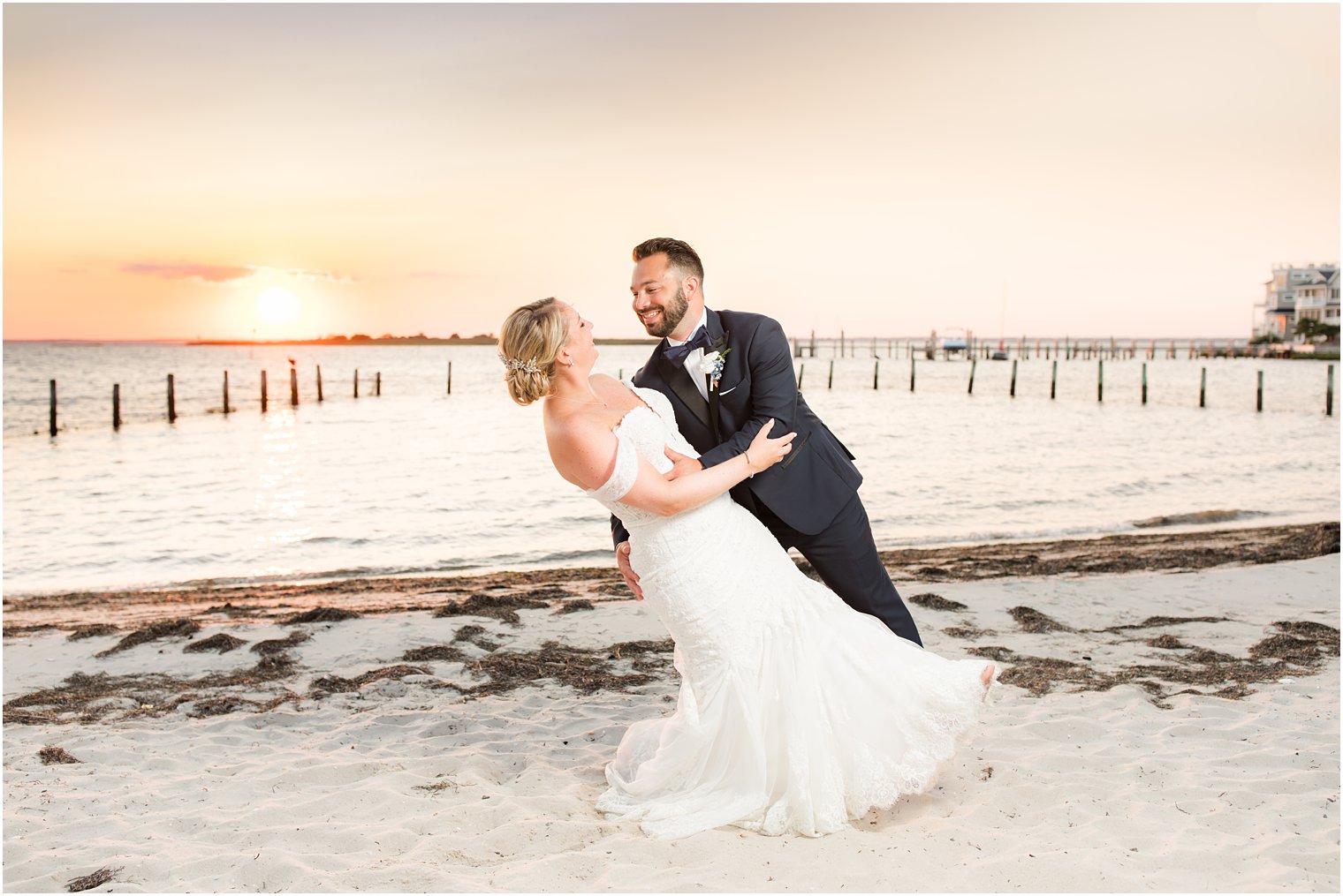 groom dips bride at sunset on Brant Beach 