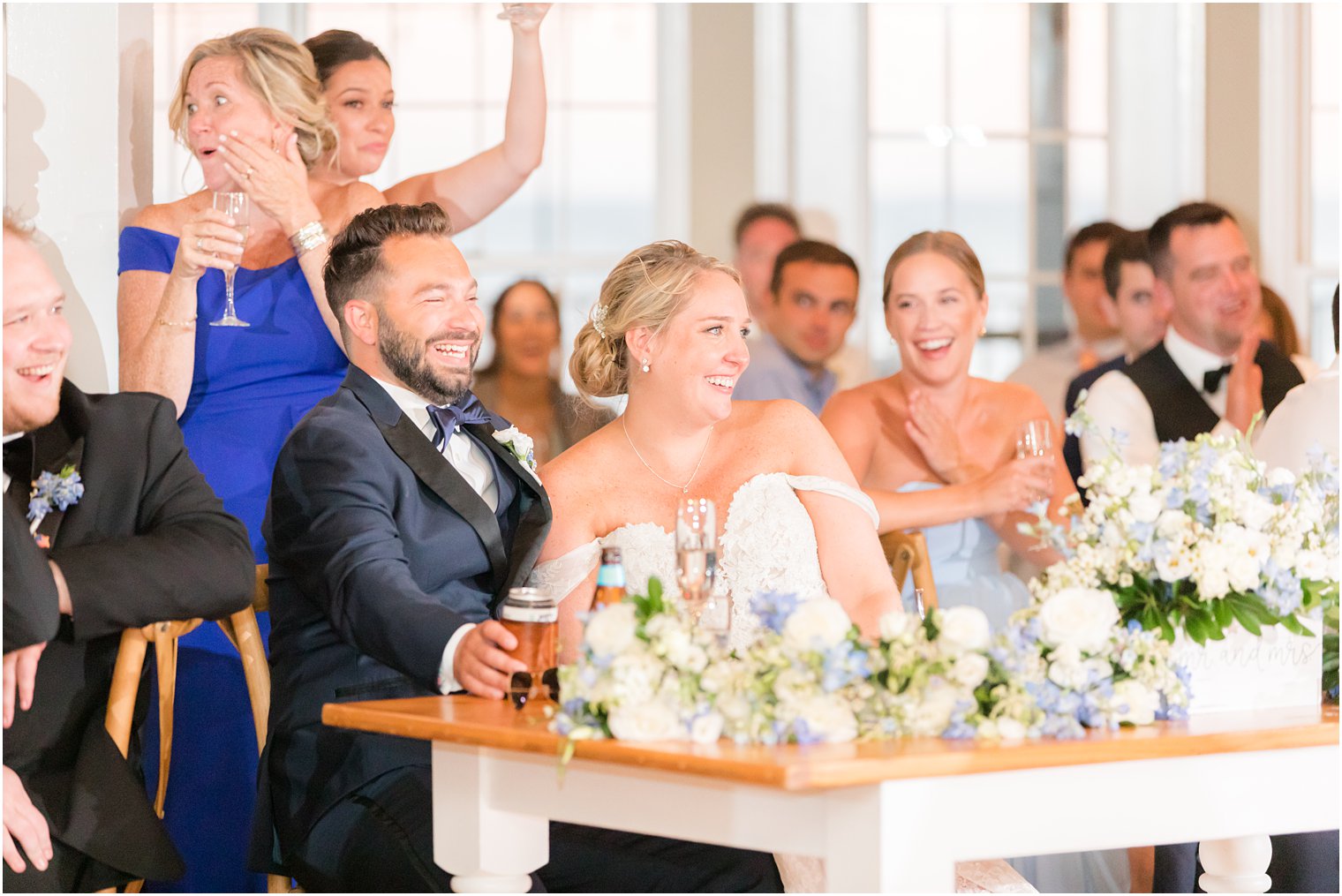 newlyweds laugh together during toasts