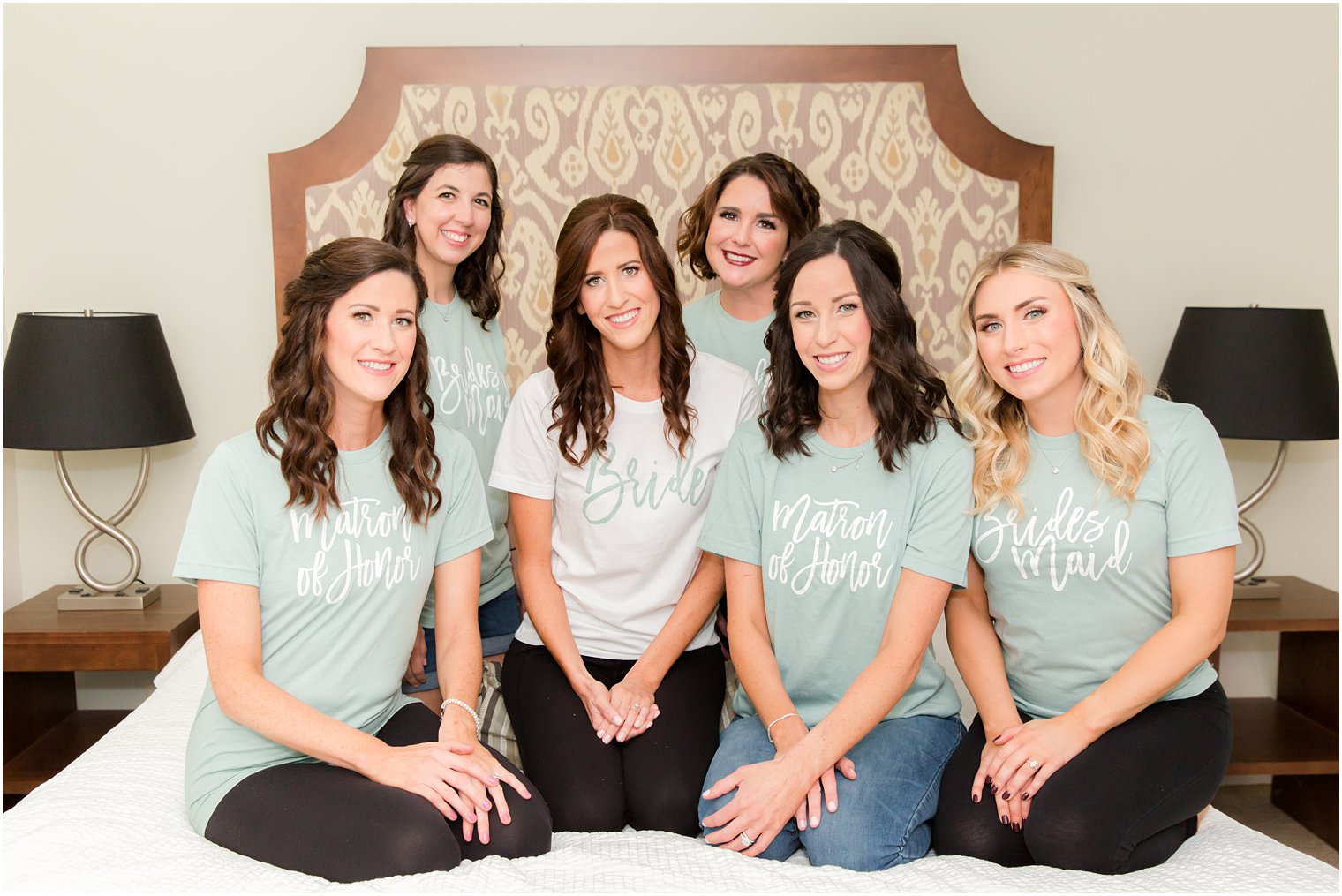 bride poses with bridesmaids in custom t0shirts on wedding morning 