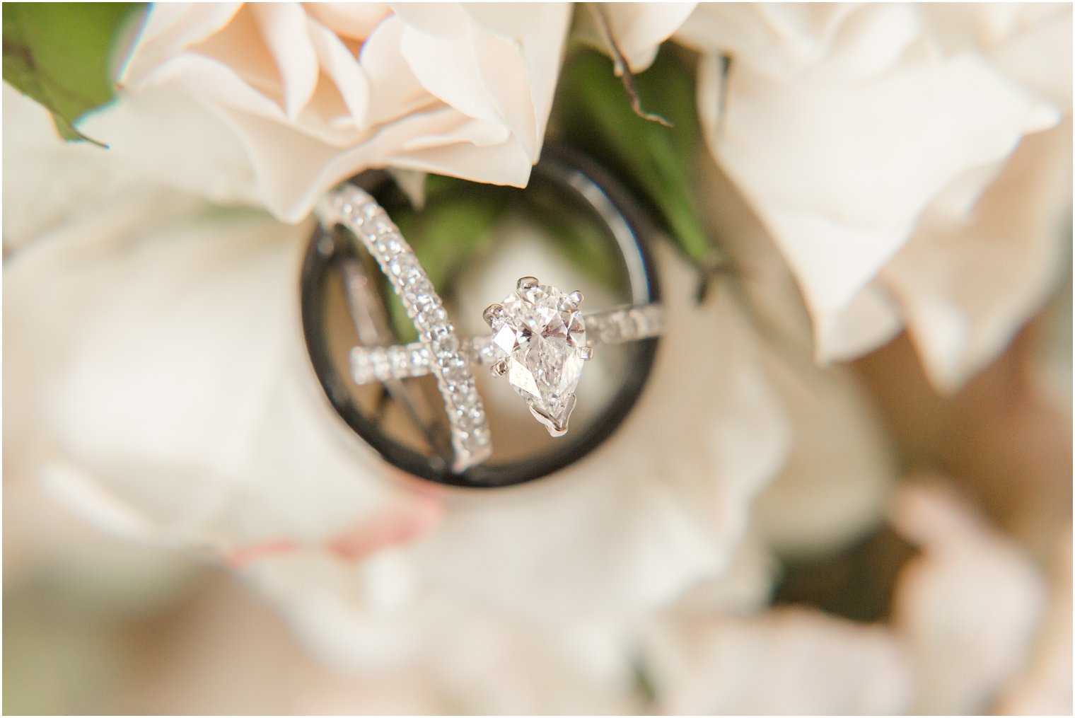 pear shaped diamond ring sits on white roses before Chauncey Hotel wedding 