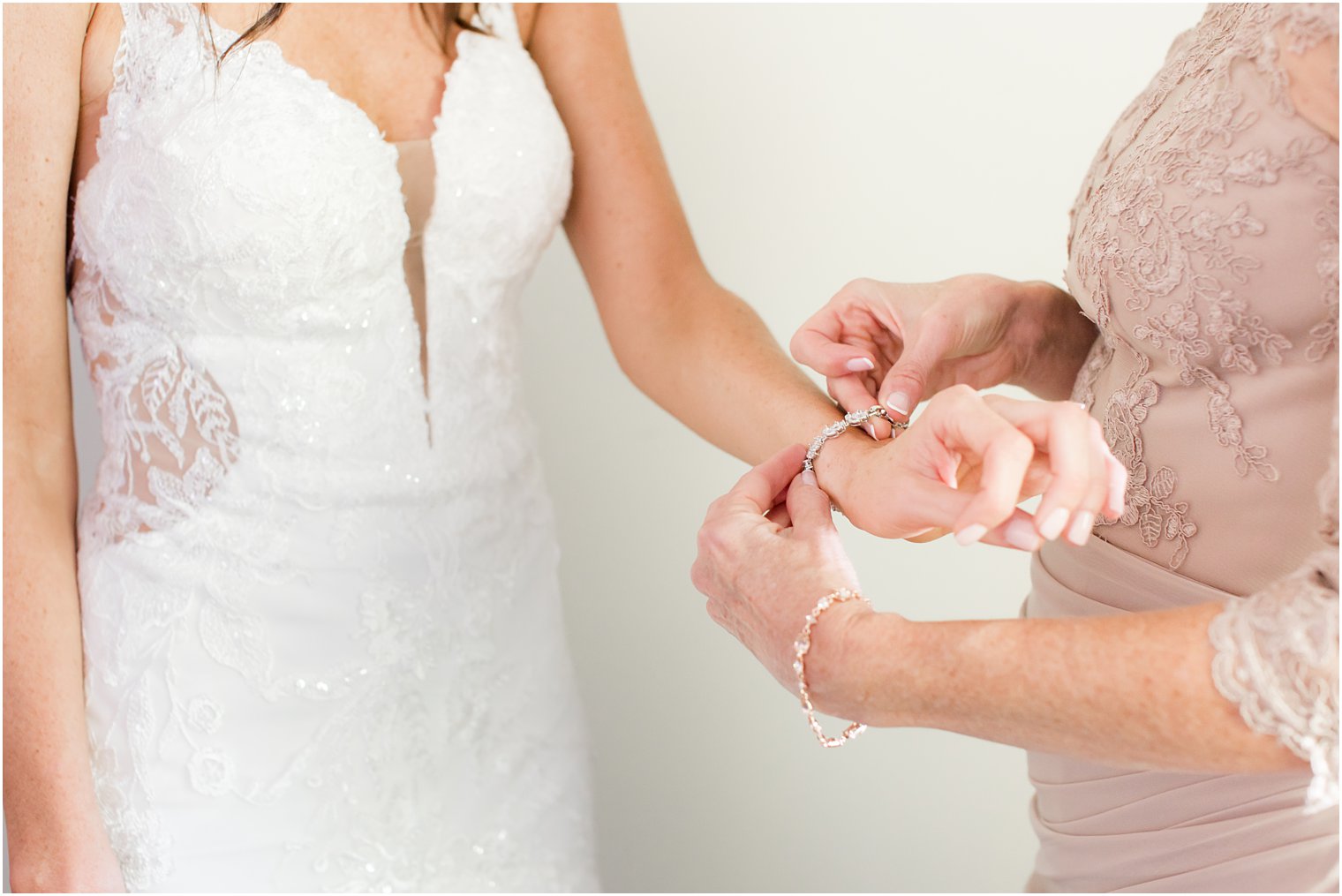 mother helps bride with bracelet on wedding day 