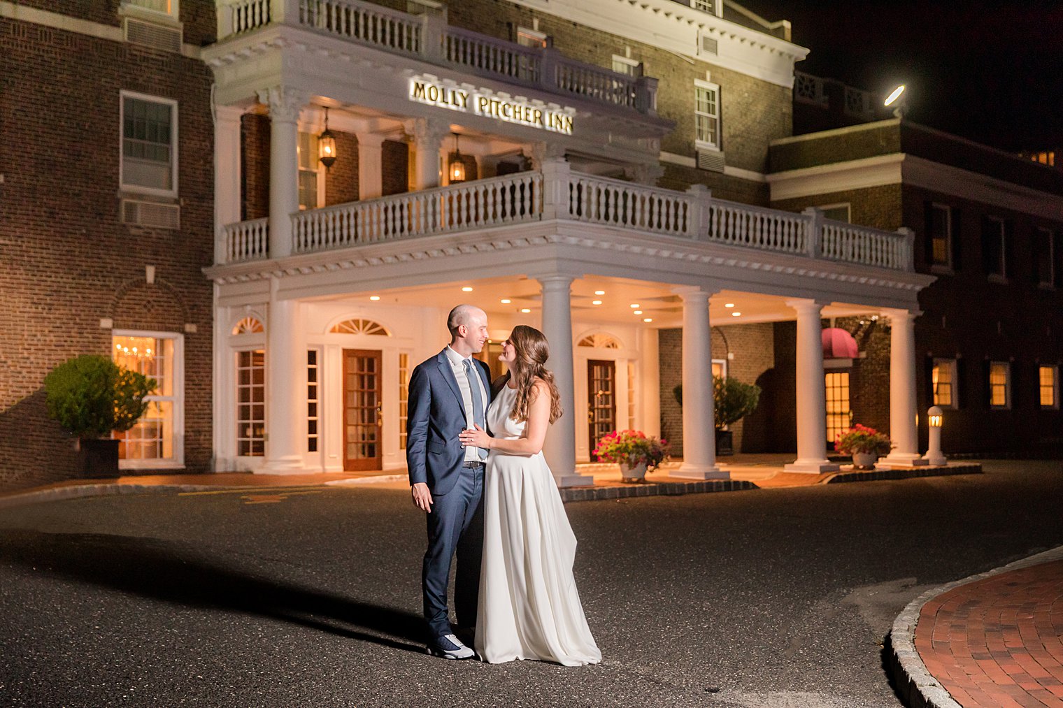 couple hugs outside building after Wedding at the Molly Pitcher Inn