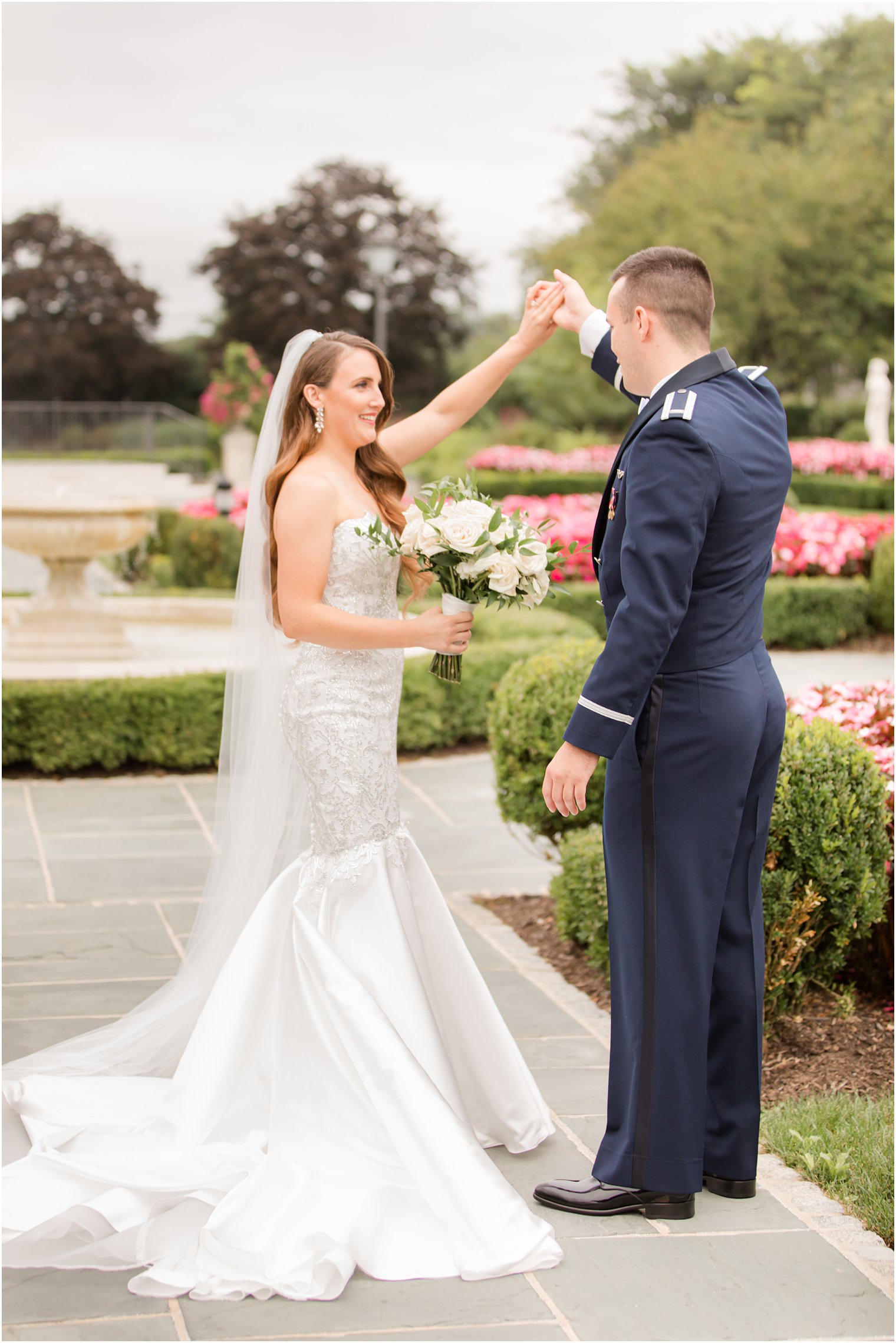 groom twirls bride during first look in gardens