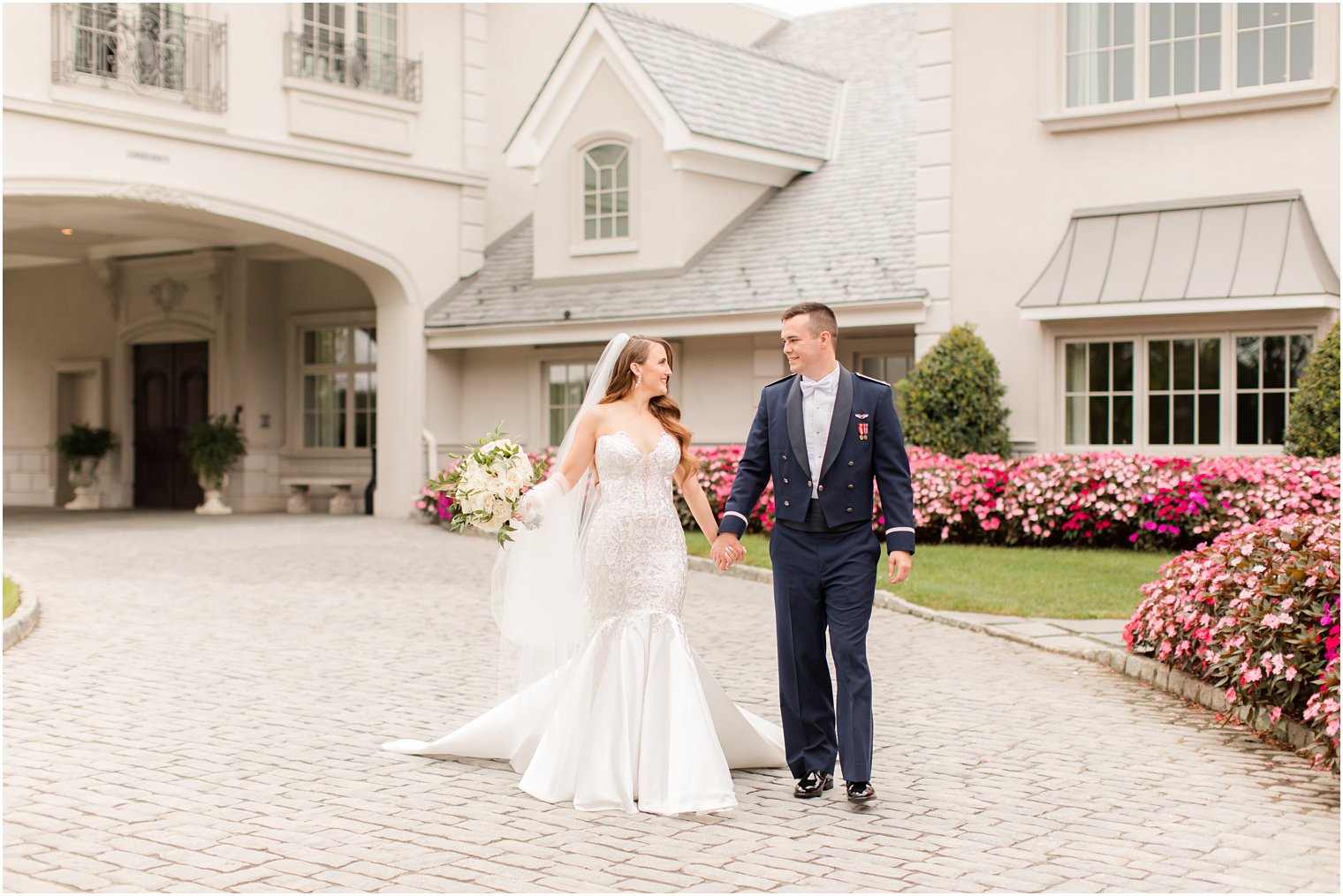newlyweds hold hands walking down driveway at Park Chateau Estate