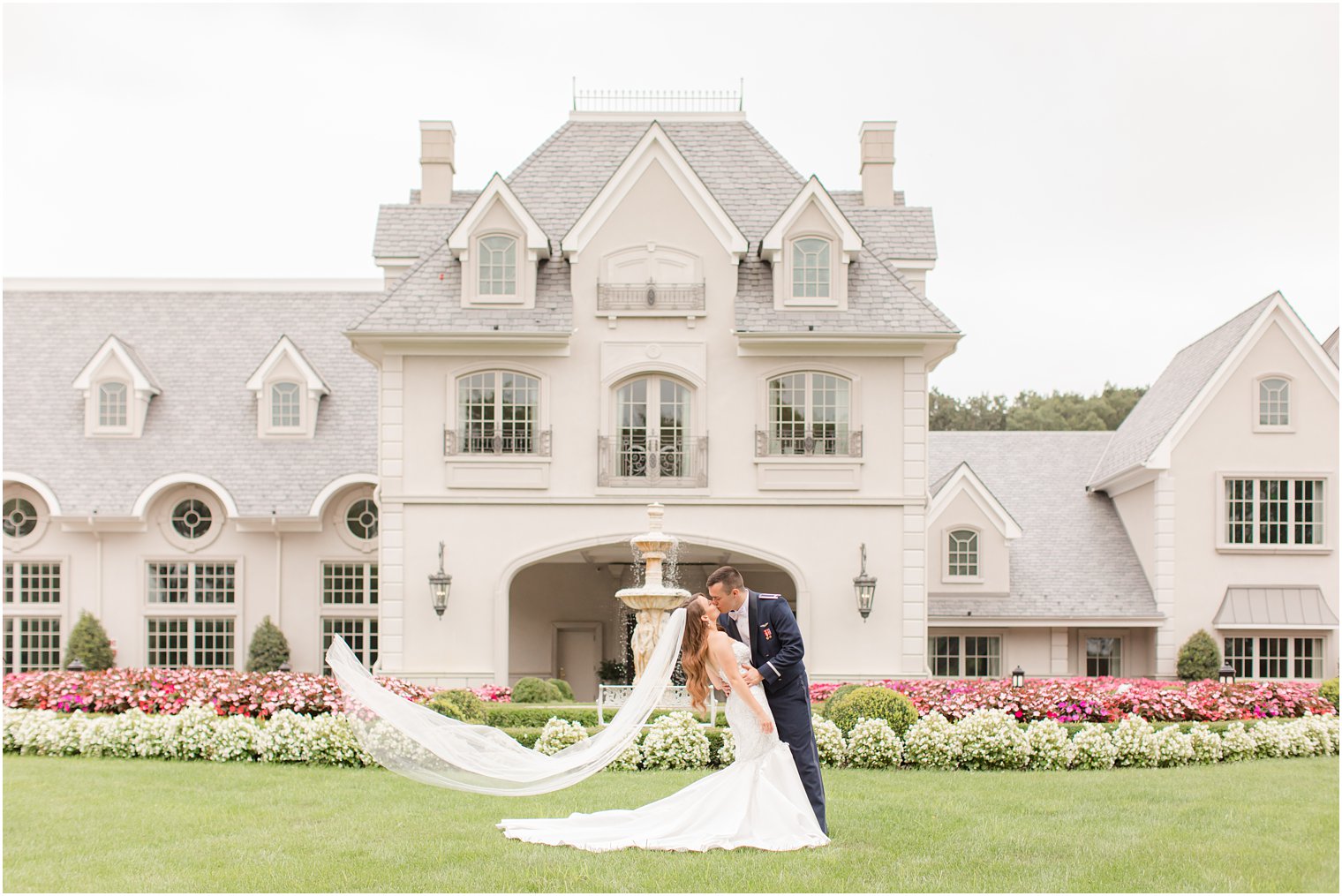 bride and groom kiss with bride's veil floating behind her at Park Chateau Estate
