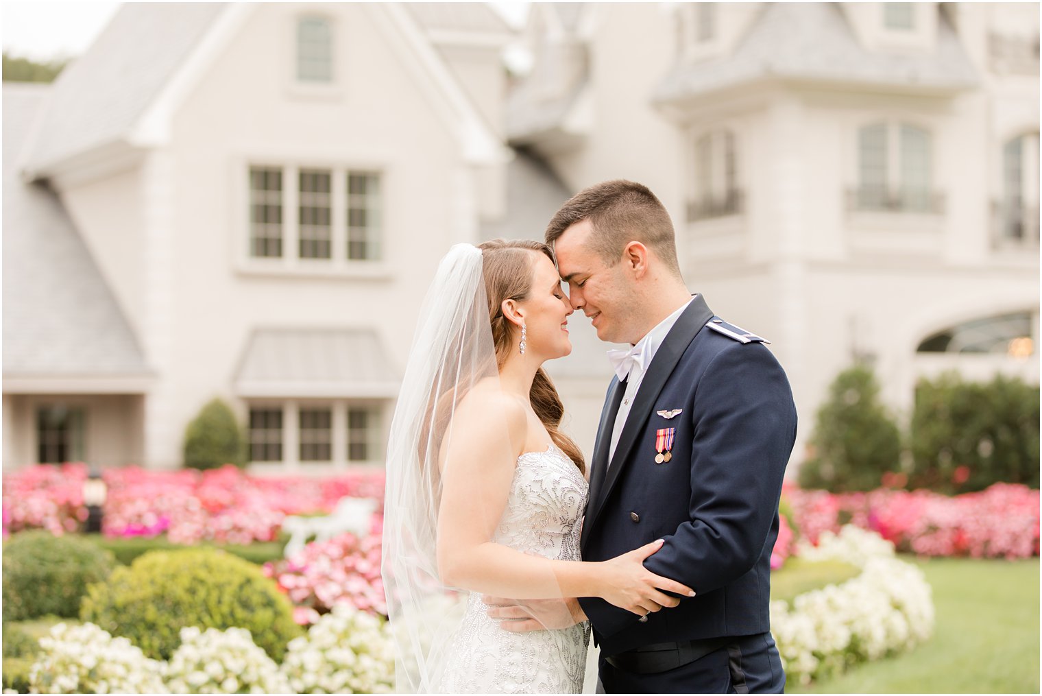 bride and groom stand with noses touching on lawn at Park Chateau Estate