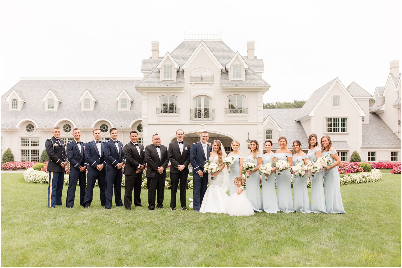 bride and groom pose on lawn at Park Chateau Estate with wedding party 
