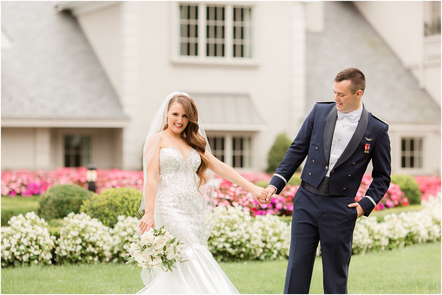 groom looks at bride's gown on lawn at Park Chateau Estate
