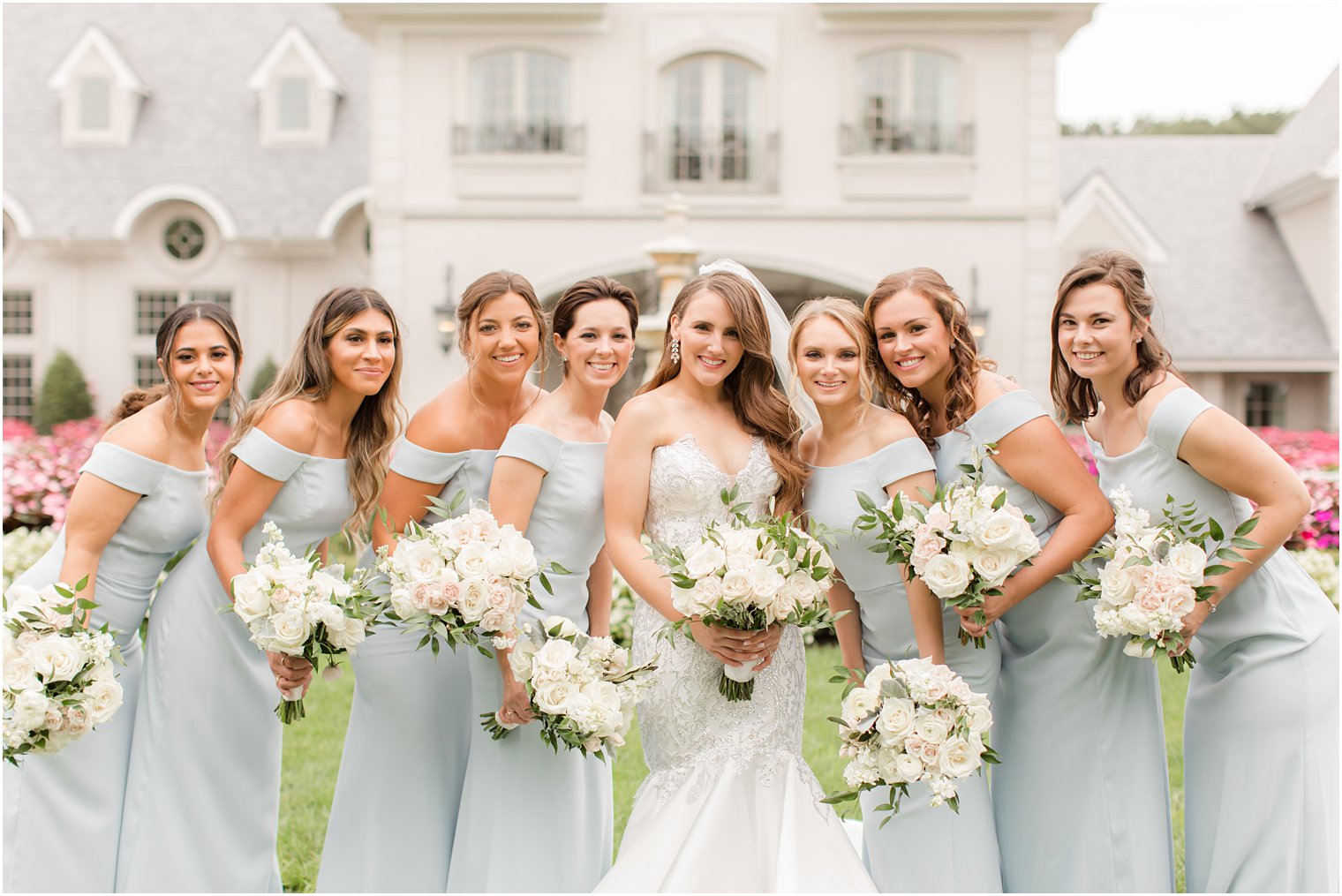 bride and bridesmaids in light blue gowns pose on lawn at Park Chateau Estate