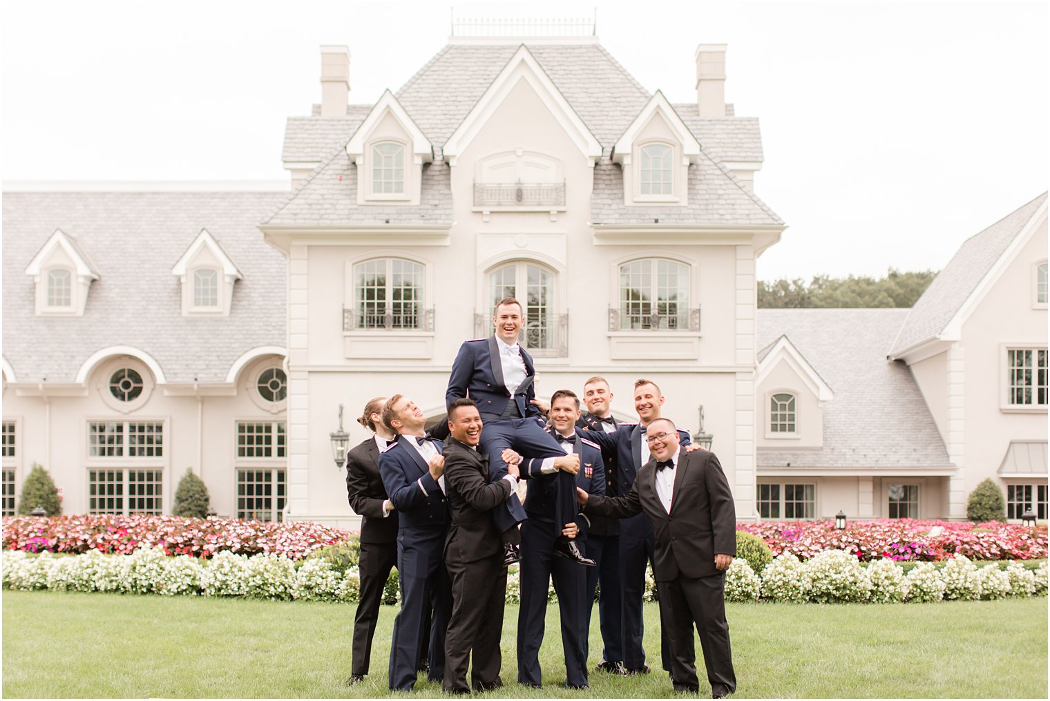 groomsmen hold up groom outside Park Chateau Estate