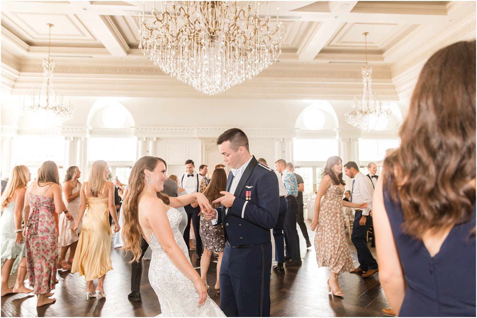 groom looks at bride's rings on dance floor during East Brunswick NJ wedding reception