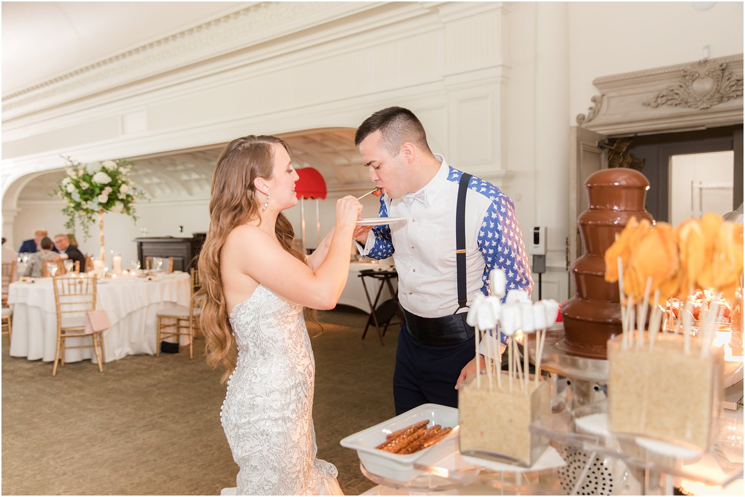 bride feeds groom during wedding reception in New Jersey 