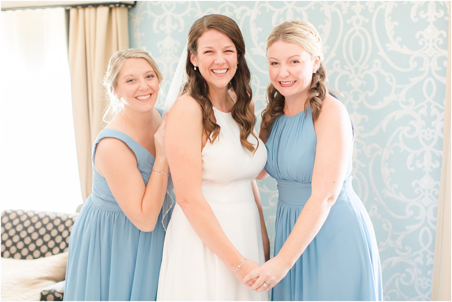 bride poses with bridesmaids in blue gowns