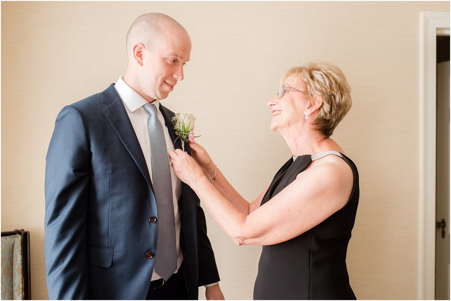 groom's mom pins on boutonniere for NJ wedding day