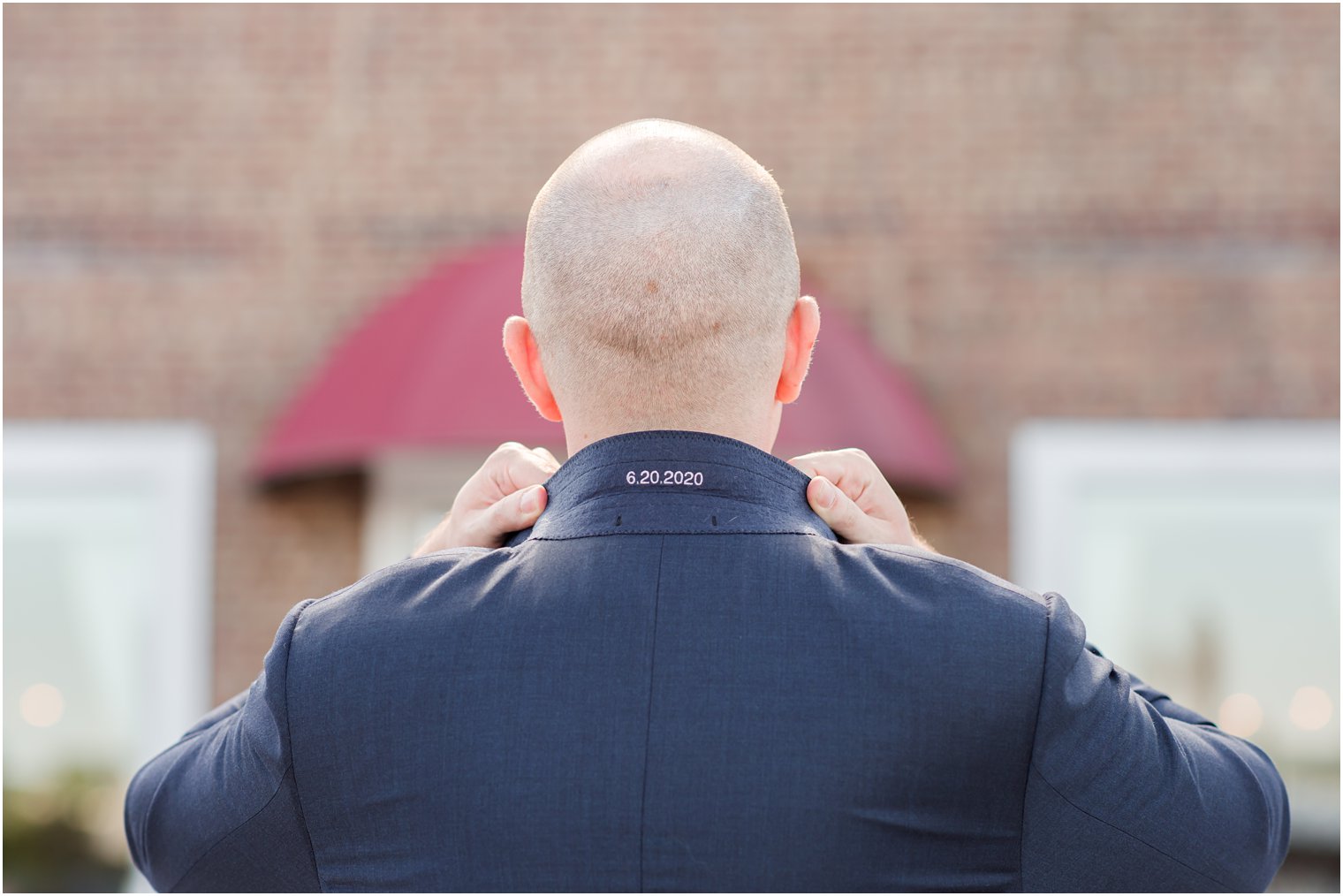 groom shows wedding date on collar of tux