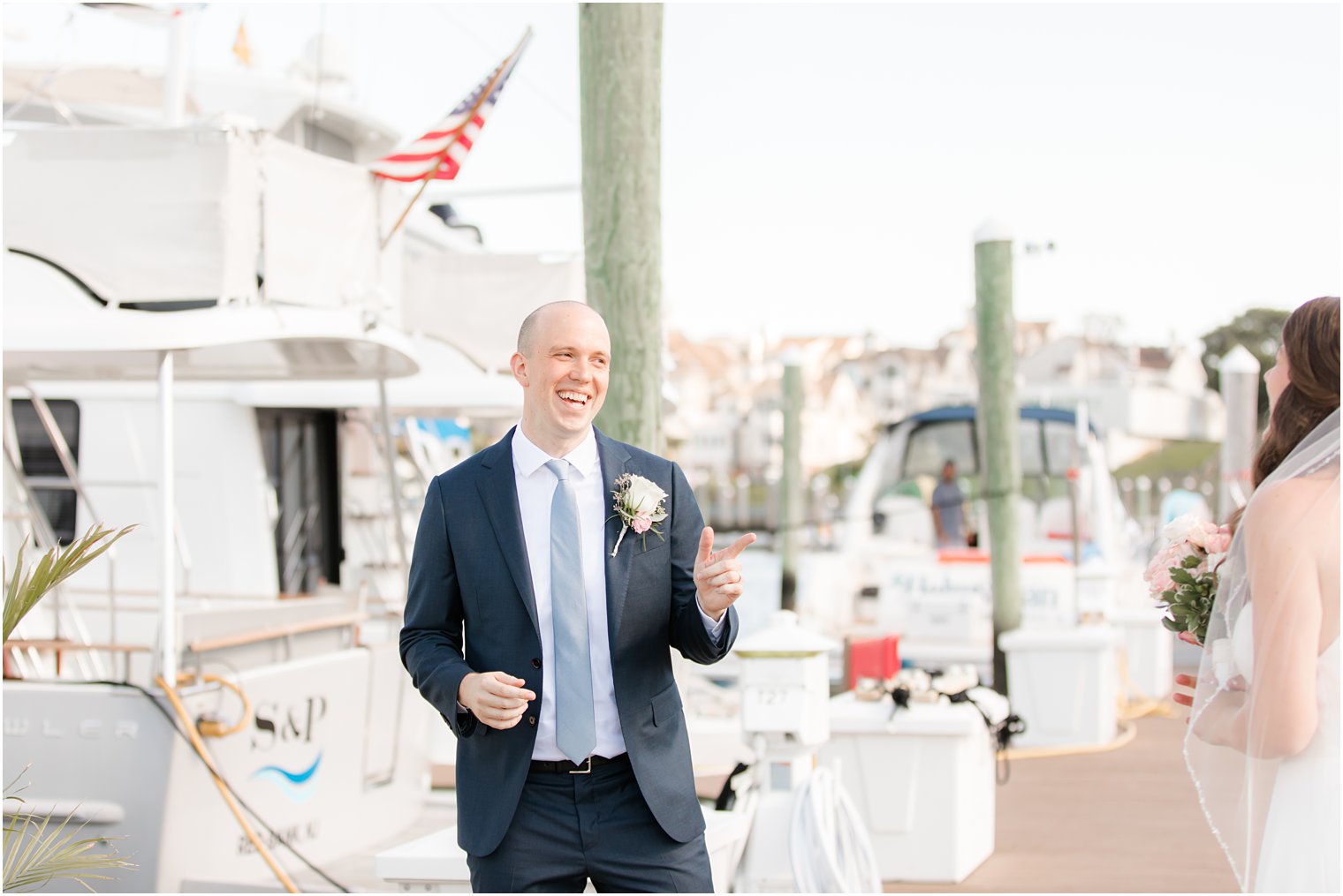 groom smiles at bride during first look on dock at Molly Pitcher Inn