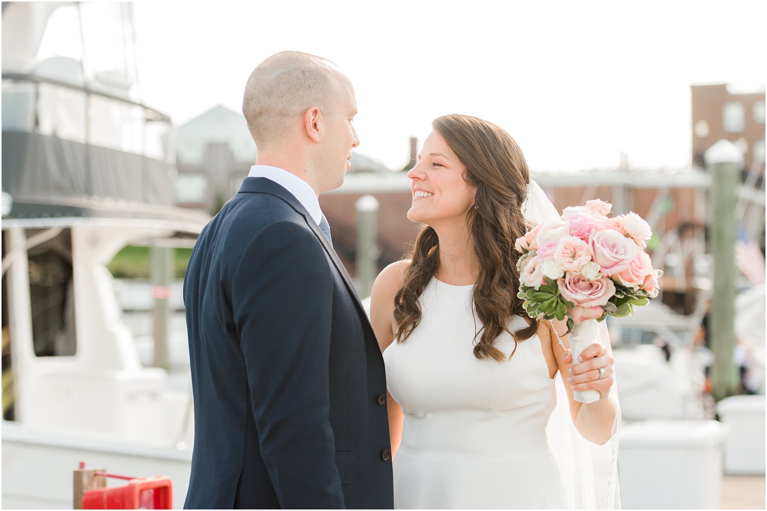 bride smiles at groom during portraits on dock at Molly Pitcher Inn