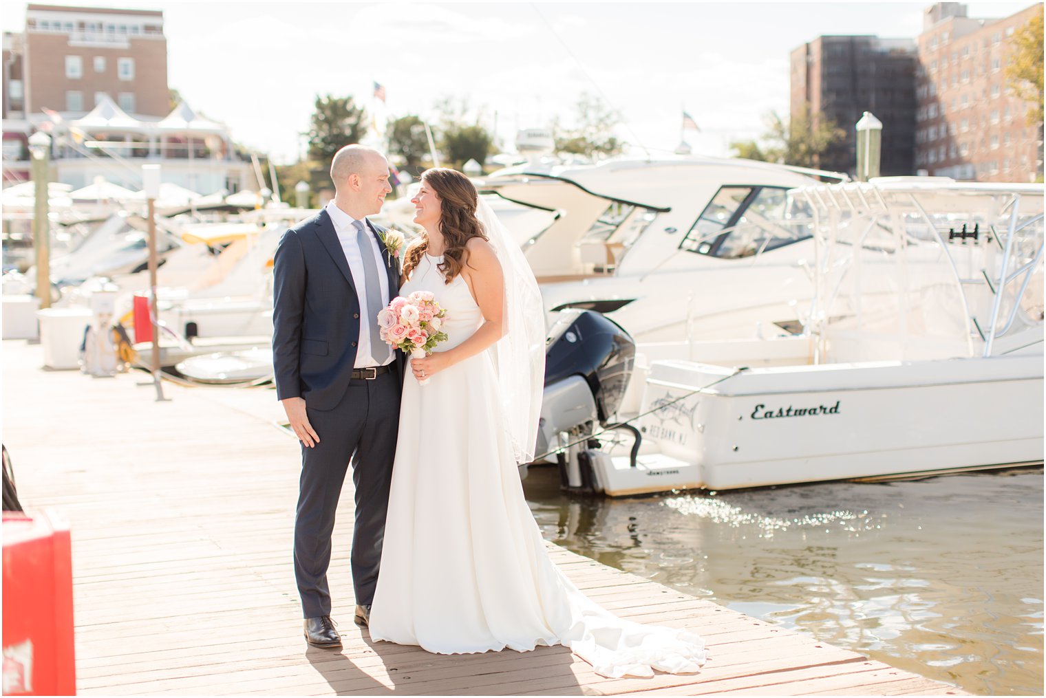 newlyweds smile at each other among boats at Red Bank NJ marina 