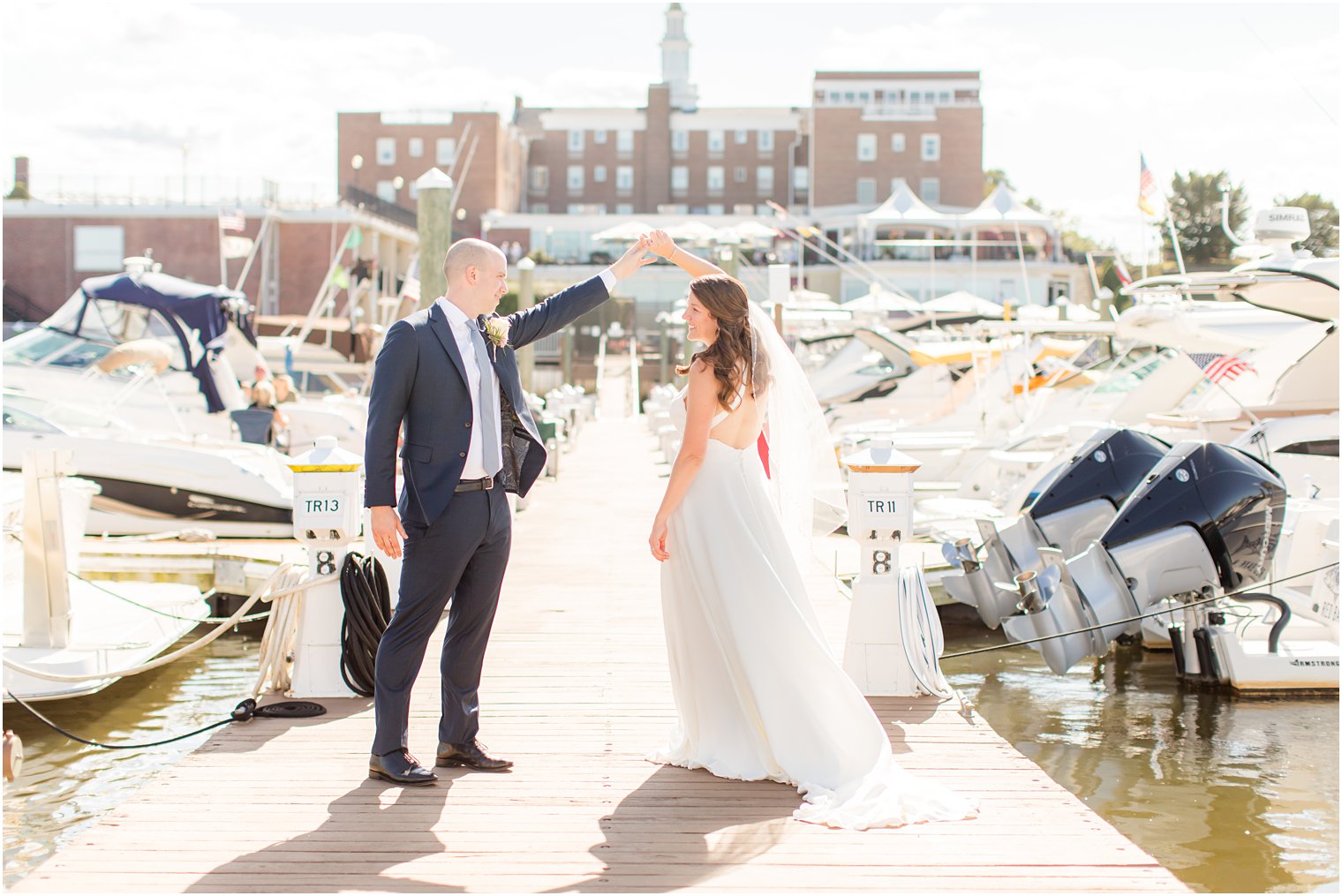 bride and groom twirl on marina at Molly Pitcher Inn