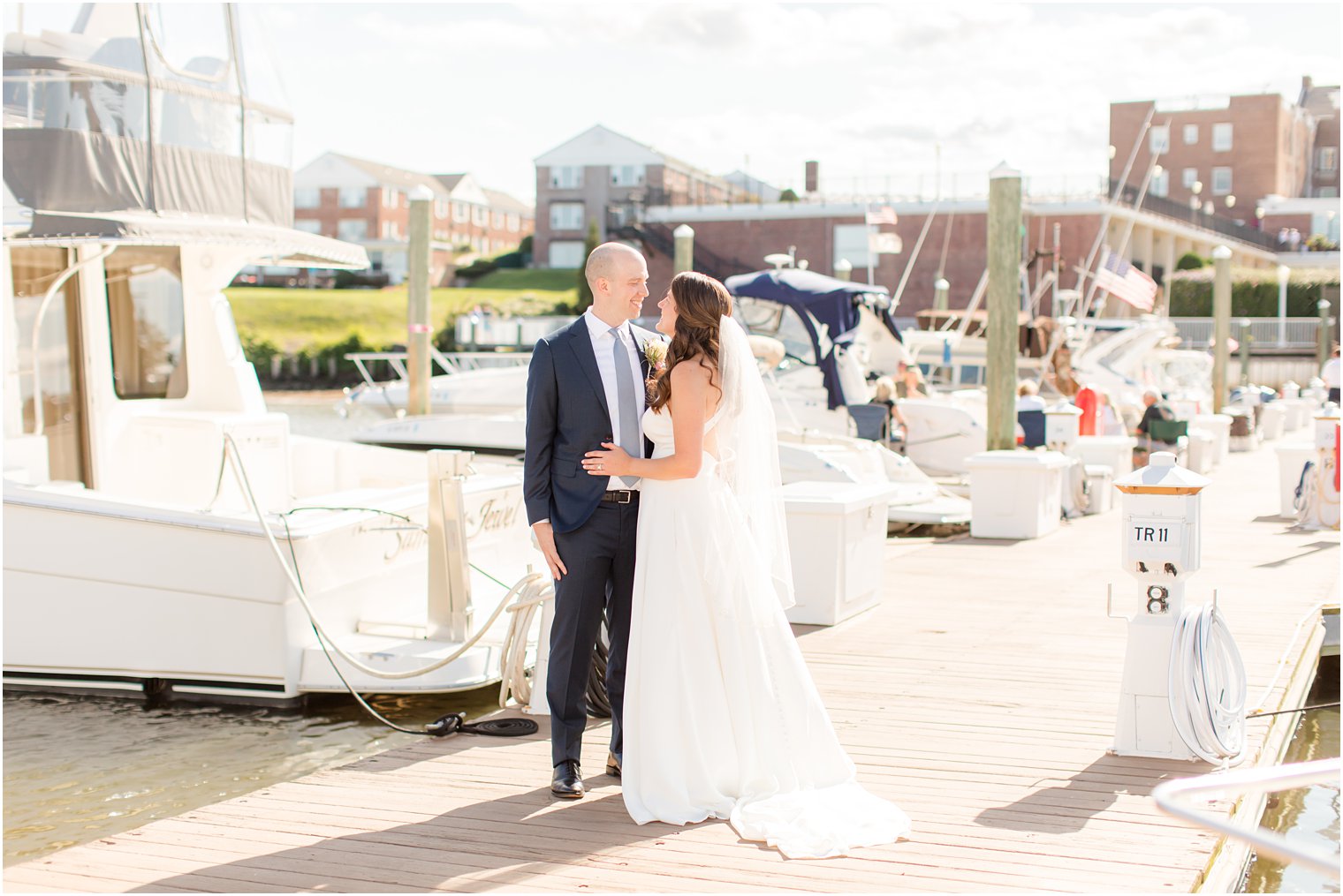 bride and groom smile at each other during portraits on Red Bank marina 