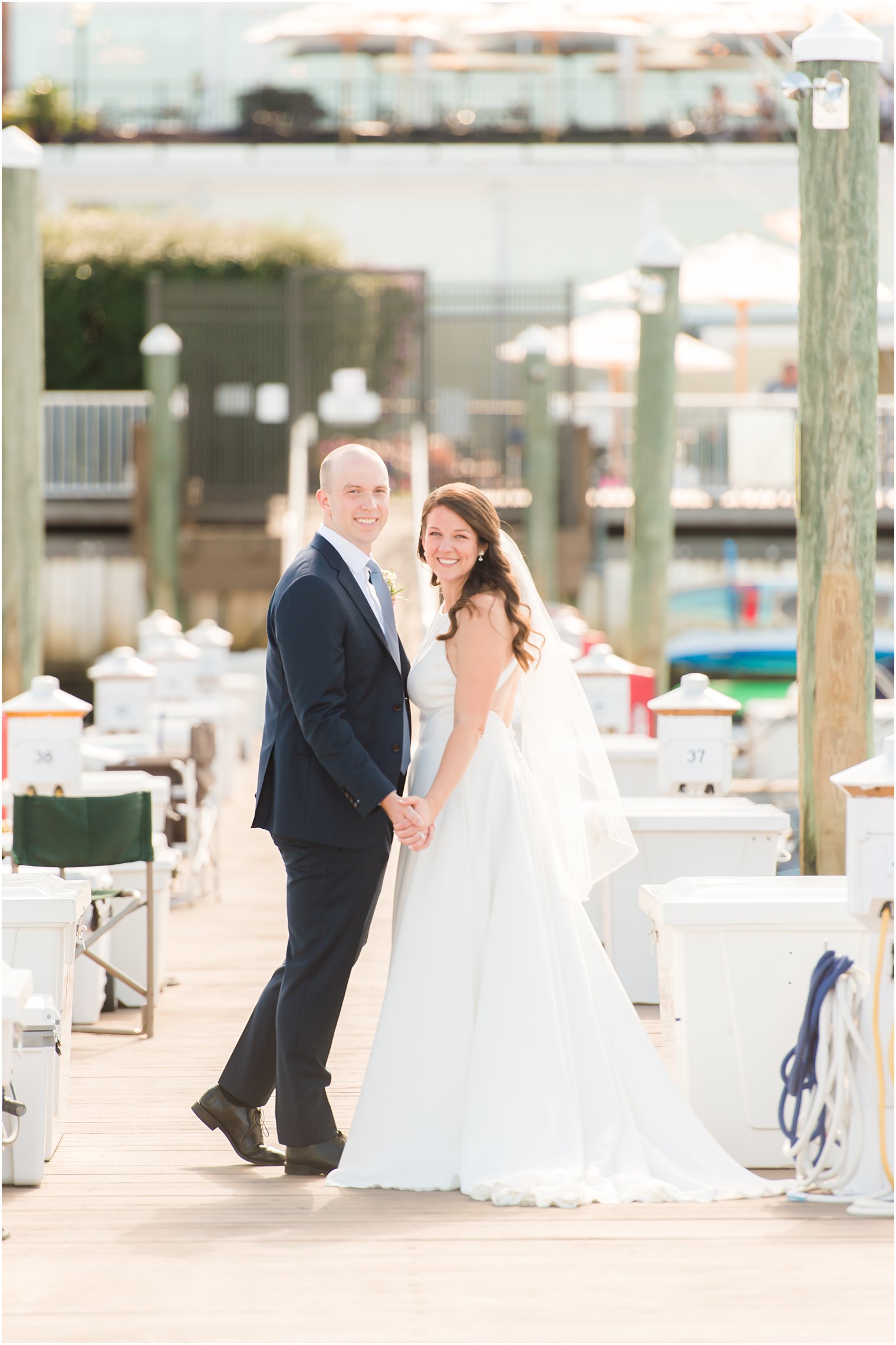 bride and groom hold hands on Red Bank marina 