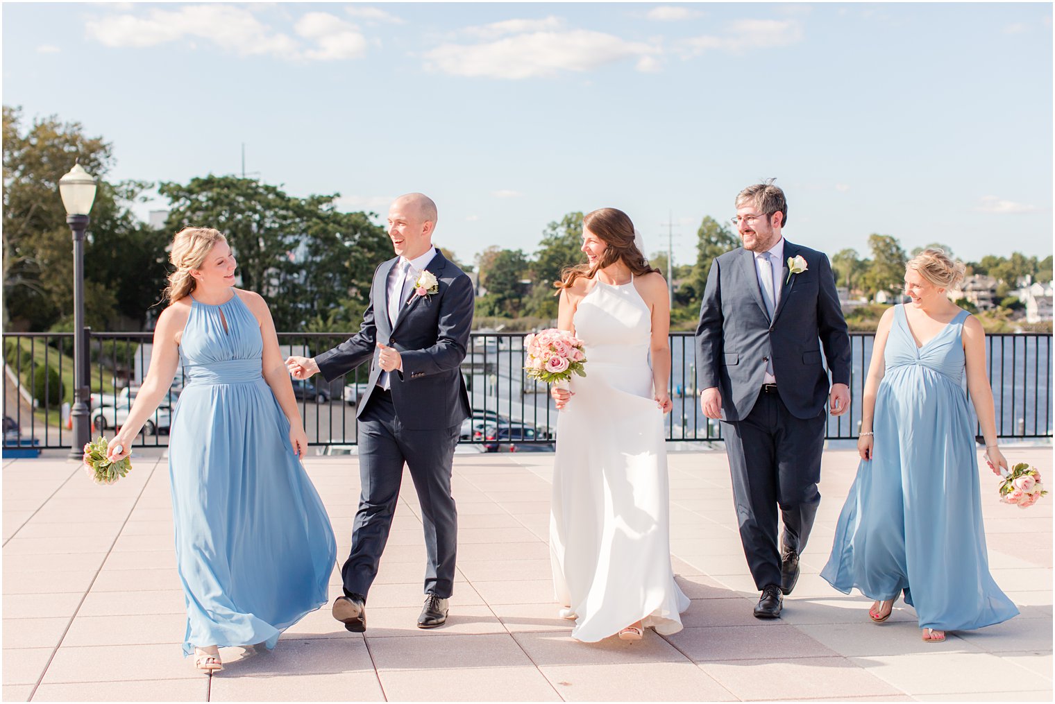 bride and groom walk with bridesmaids and groomsman 