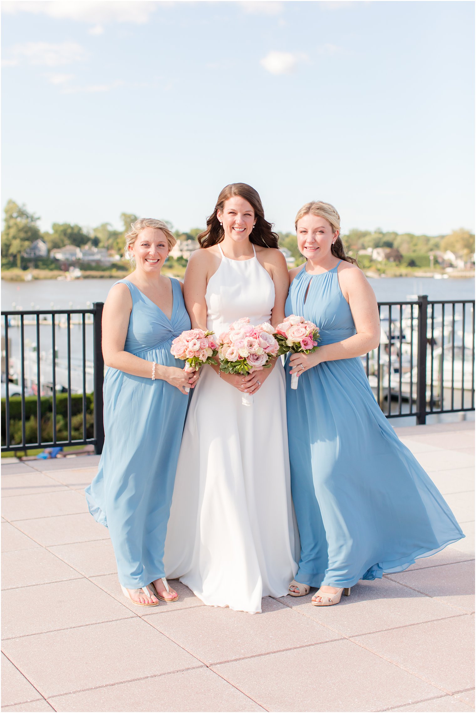 bride poses with bridesmaids in blue gowns in Red Bank NJ