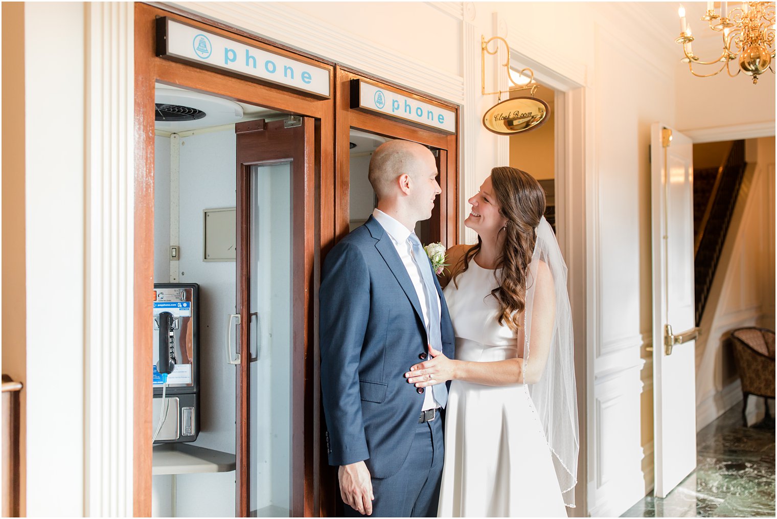 bride and groom pose by old telephone booth in Molly Pitcher Inn