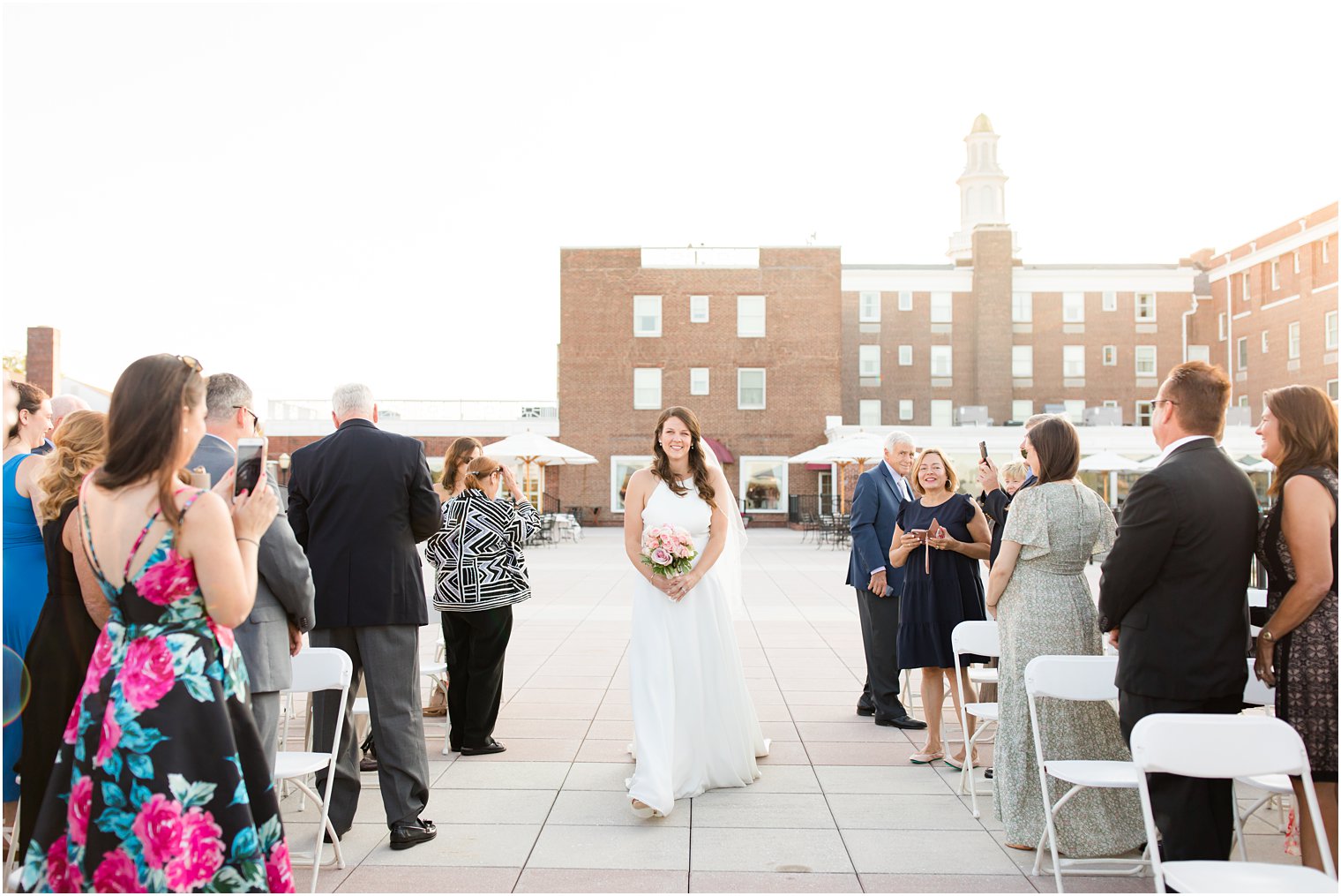 bride walks down aisle during outdoor waterfront wedding ceremony in Red Bank NJ