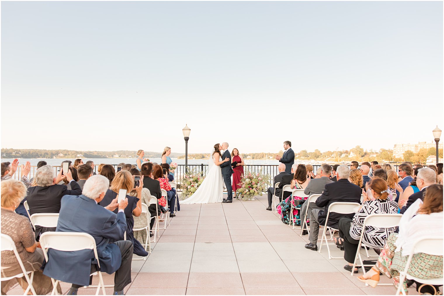 bride and groom kiss during outdoor waterfront wedding ceremony in Red Bank NJ