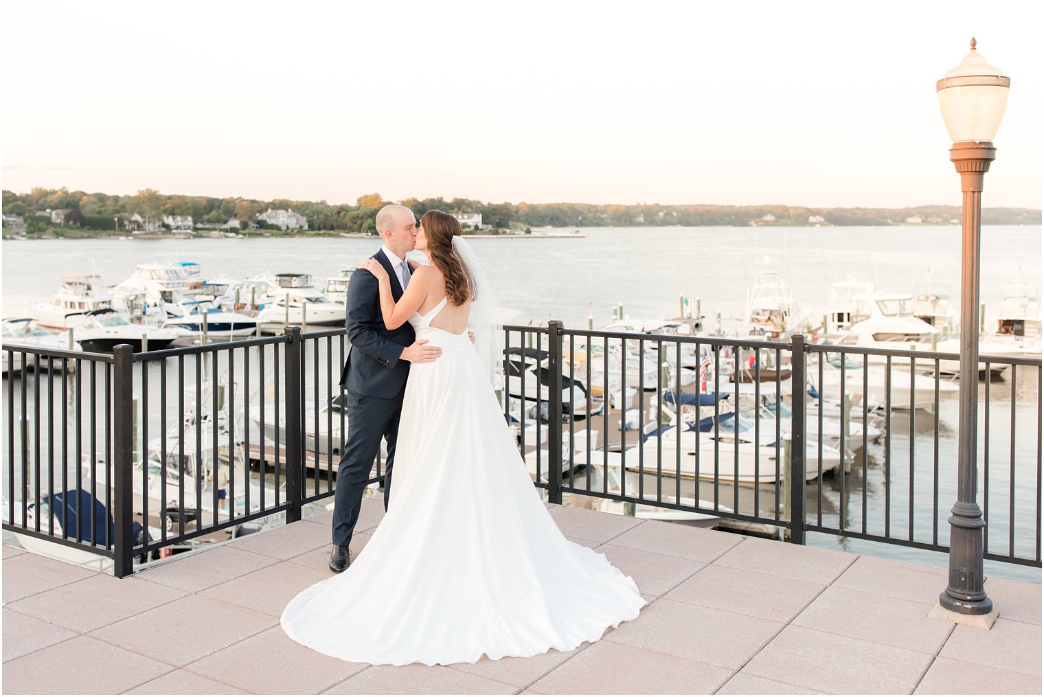 bride and groom kiss overlooking marina in Red Bank NJ