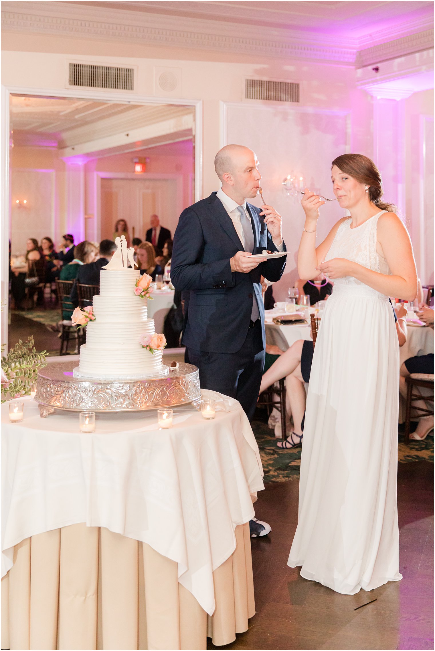 bride and groom taste wedding cake during NJ wedding reception 