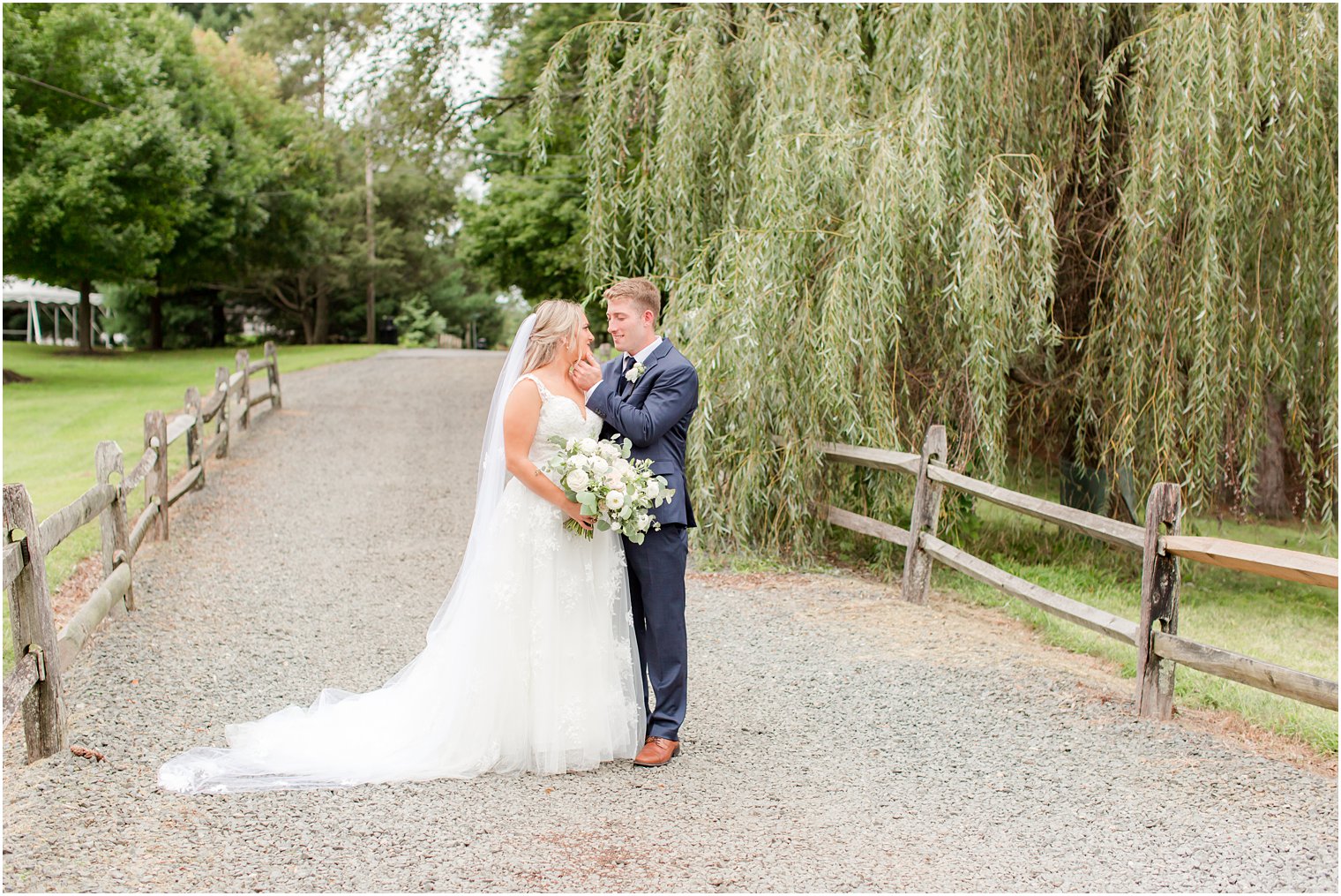 groom holds bride's chin smiling at her 