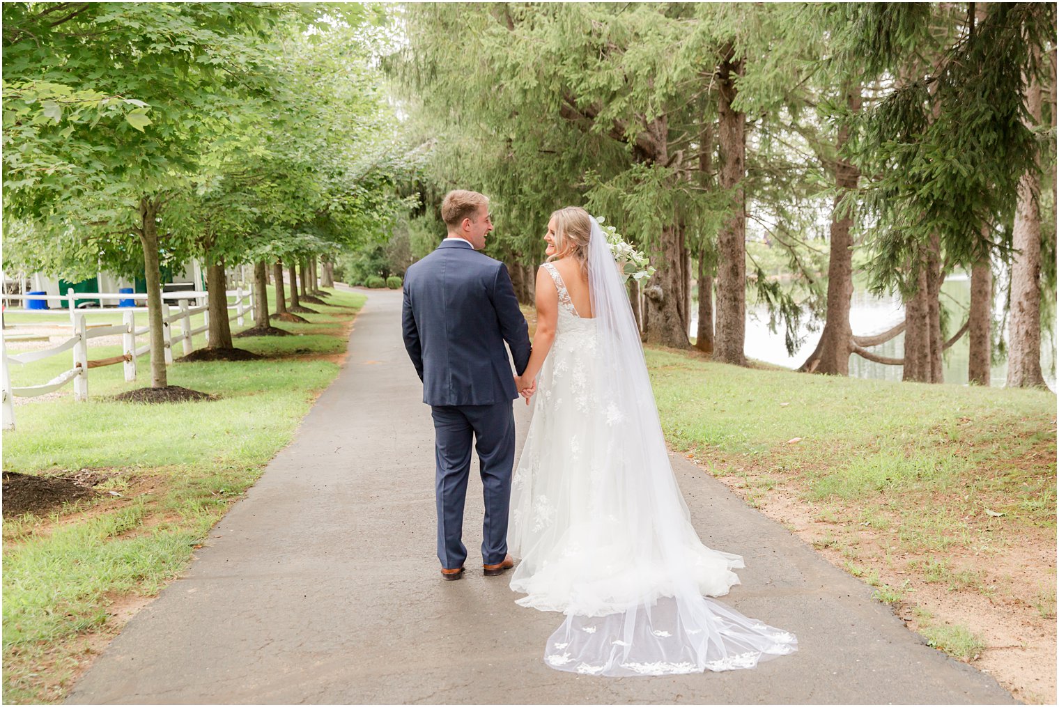 bride and groom walk down pathway at Windows on the Water at Frogbridge