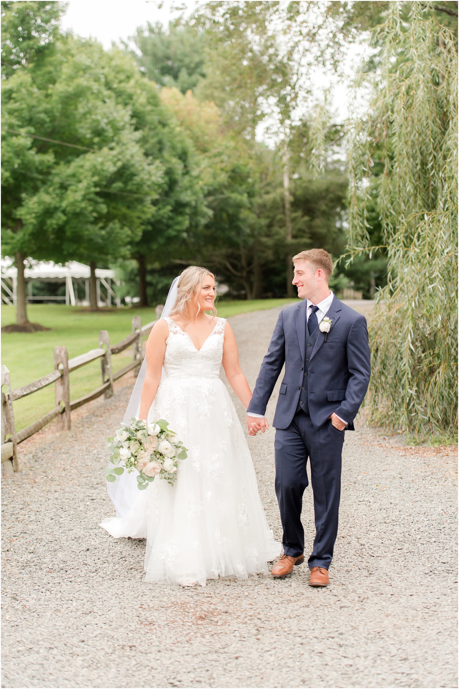 newlyweds walk through path at Windows on the Water at Frogbridge